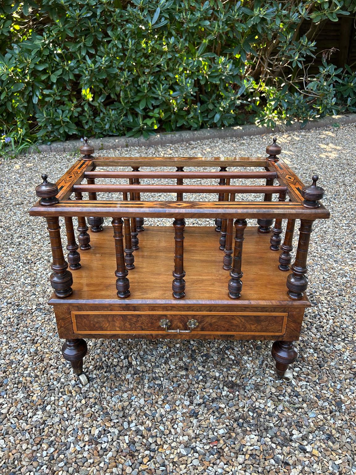 Canterbury in radica vittoriana del XIX secolo con tre sezioni dotate di supporti finali originali torniti per riporre riviste o libri. La base è dotata di un cassetto singolo rivestito in mogano con maniglia in ottone, sollevato su piedi torniti
