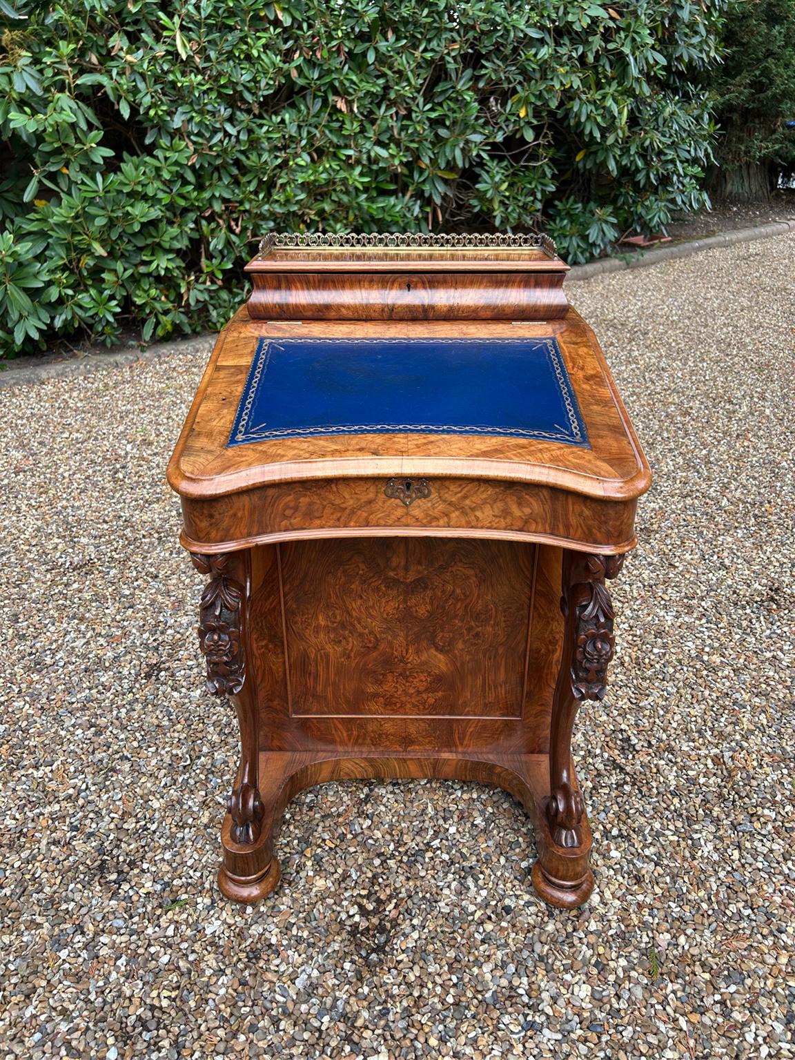 Davenport en ronce de noyer de l'époque victorienne du 19e siècle, avec des supports cabriolés sculptés sur une surface d'écriture inclinée et recouverte de cuir. Intérieur en satiné avec deux tiroirs et deux tiroirs factices. Galerie en laiton