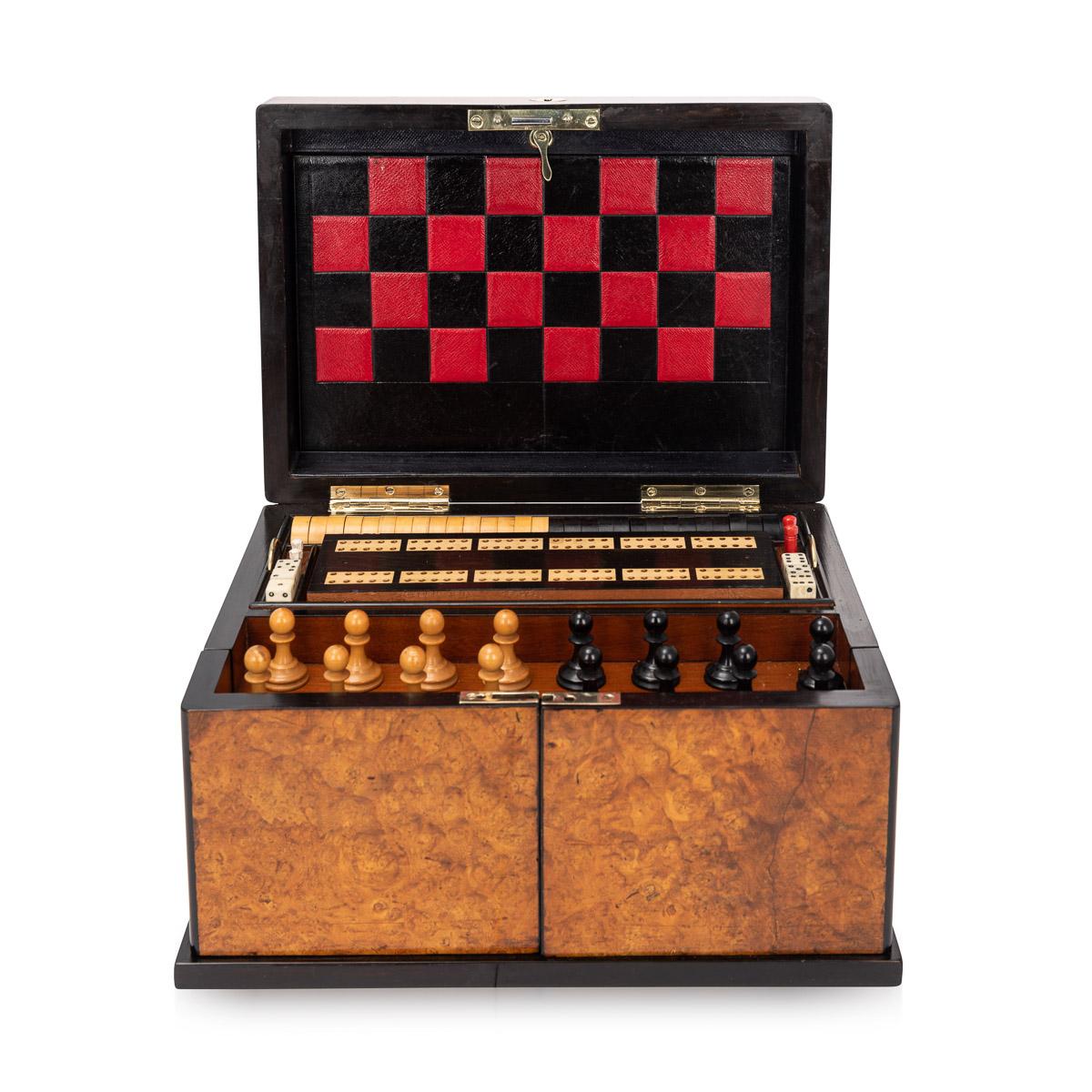Antique late-19th century Victorian burr walnut cased games compendium, the interior comprising a boxwood and ebony chess set, draughts, dominoes, dice, cribbage board with markers, leather bound boards for games, playing cards, droughts counters, a