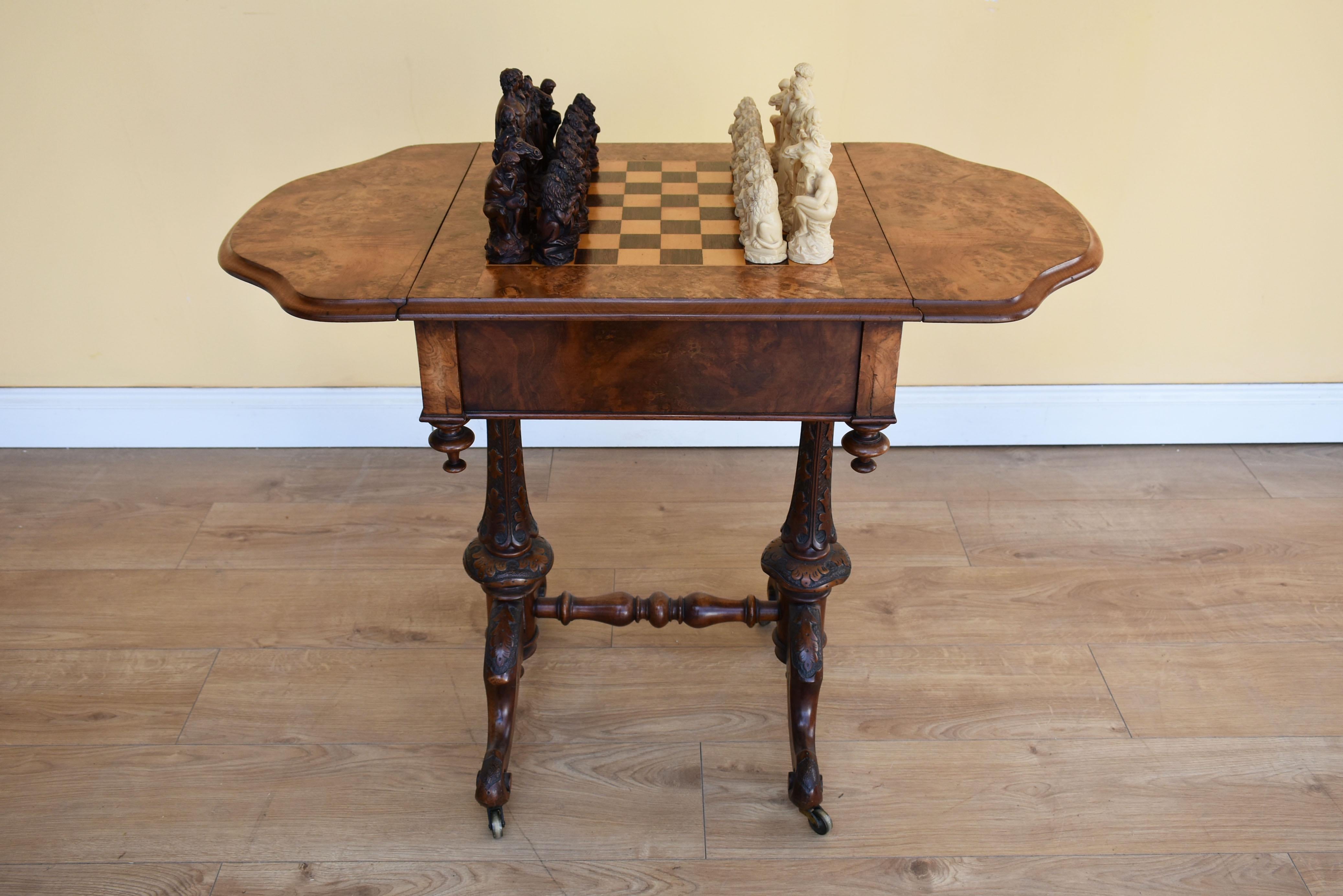 For sale is a good quality Victorian burr walnut games table, with an inlaid chess top with shaped drop leaves and a frieze drawer, raised on bulbous carved standard ends. This piece is in excellent, original condition and comes complete with chess