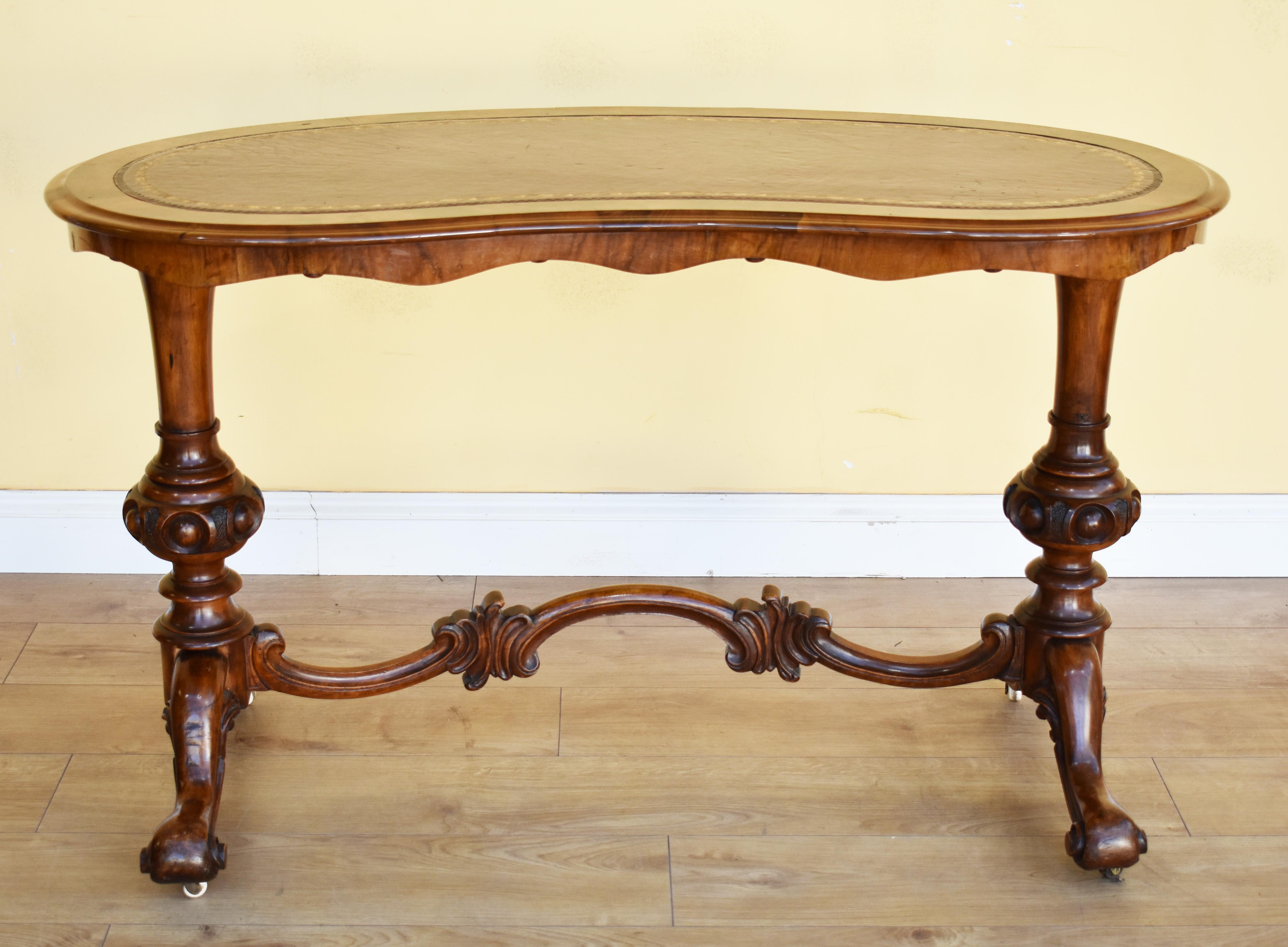For sale is a good quality 19th century Victorian burr walnut kidney shaped ladies writing table. The top is inset with a maroon leather skiver, decorated with gold tooling. Below this is a nicely shaped frieze, flanked by two turned and carved