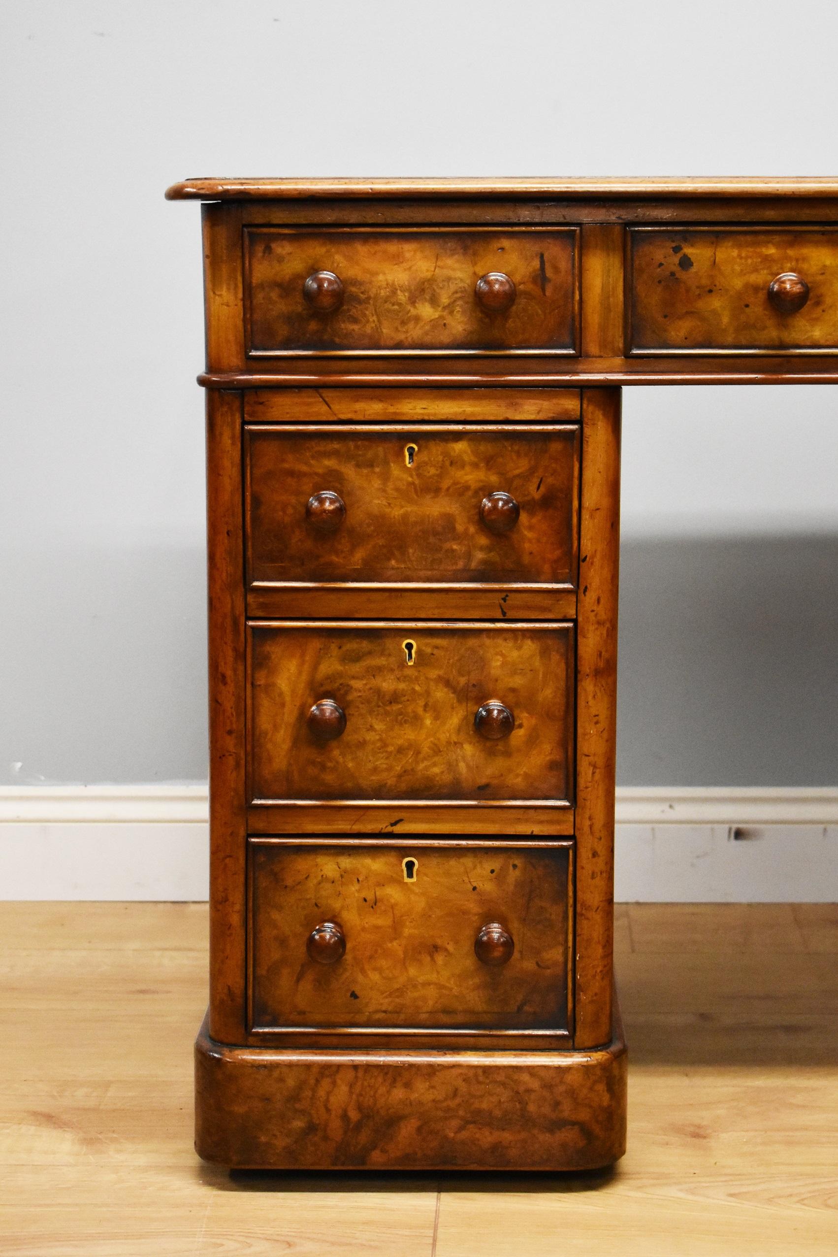 For sale is a good quality Victorian Burr walnut pedestal desk, the top having a maroon leather writing surface, decorated with gold tooling, above three drawers, one long drawer in the centre, flanked by a short drawer on either side. The desk top