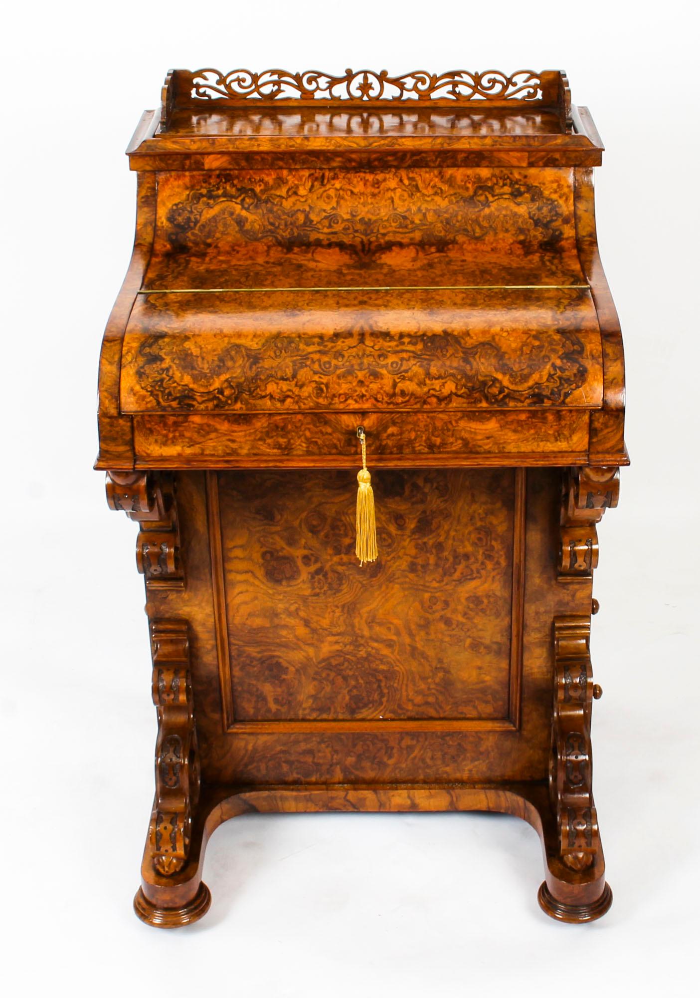 This is a gorgeous antique piano front Davenport Desk, circa 1860 in date.

It is crafted from fabulous burr walnut and the hinged pull out writing slope features the original inset gilt tooled navy leather writing surface, ink bottles and pen