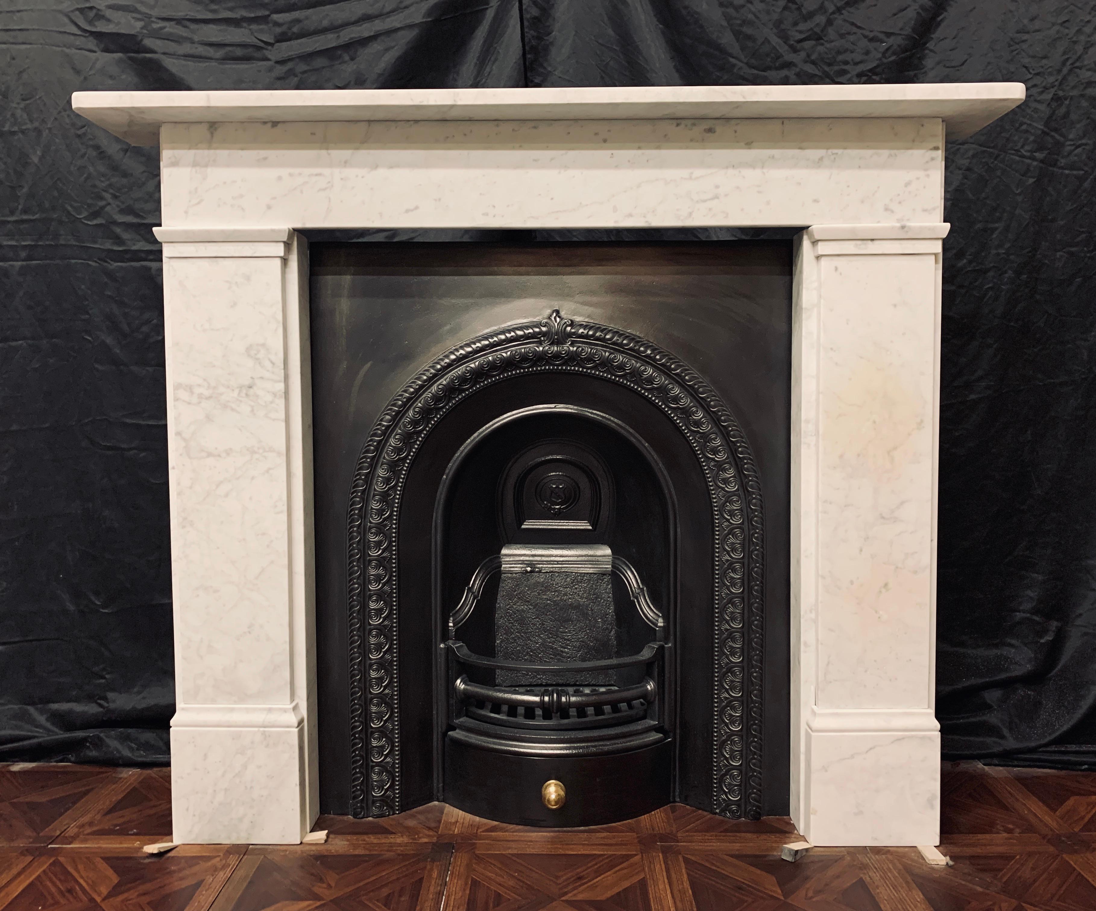 A small and attractive 19th century Victorian marble fireplace surround of simple form, a square shelf sits above a plain straight through frieze, supported by stepped jambs with block and capping moulding to the frieze line, all resting on moulded