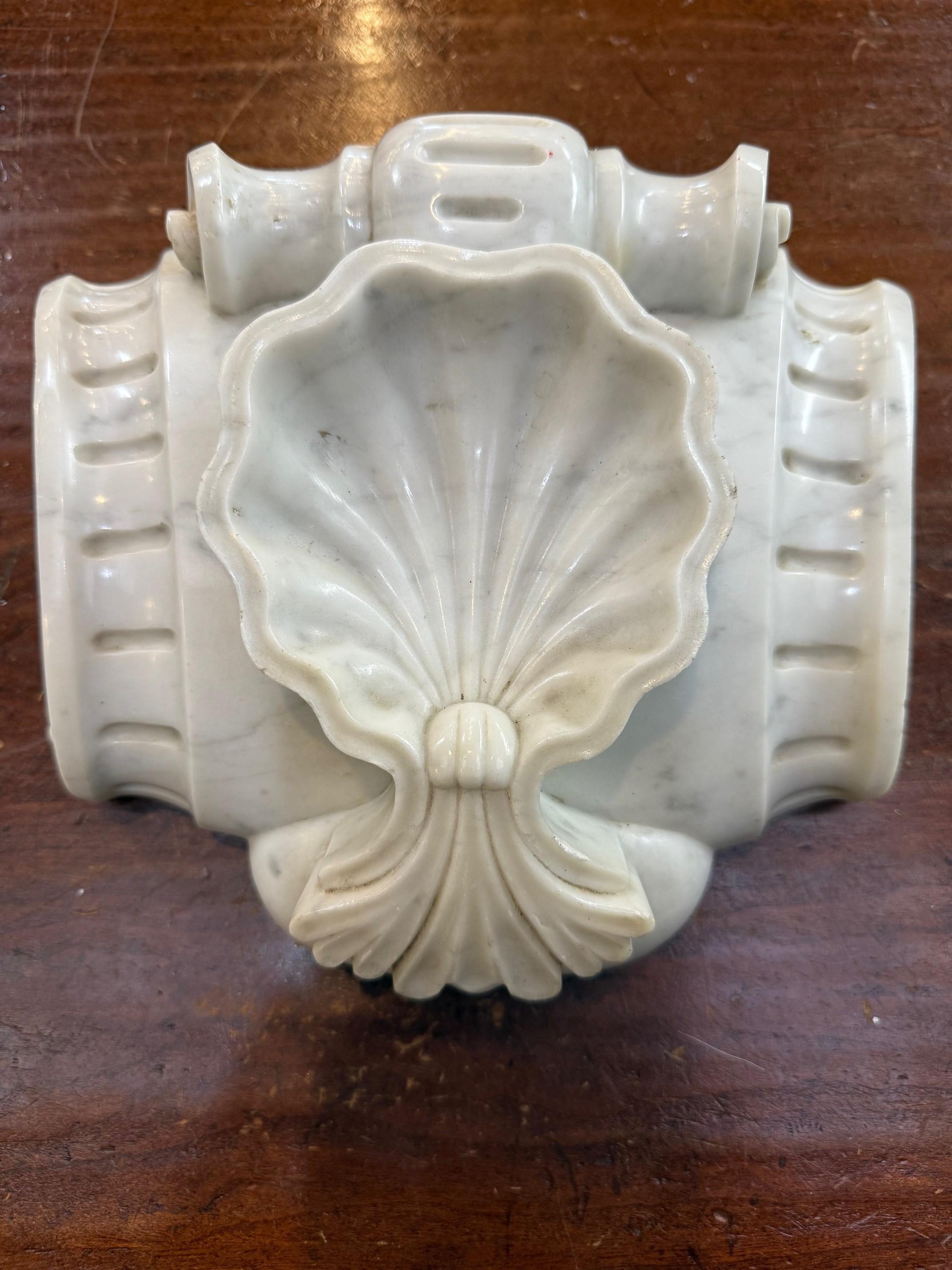 A 19th Century Victorian carrara marble mantel keystone with a carved scallop shell. This is a beautiful antique carved marble fireplace mantel keystone, featuring a scallop shell design. These keystones were often the decorative centerpiece of