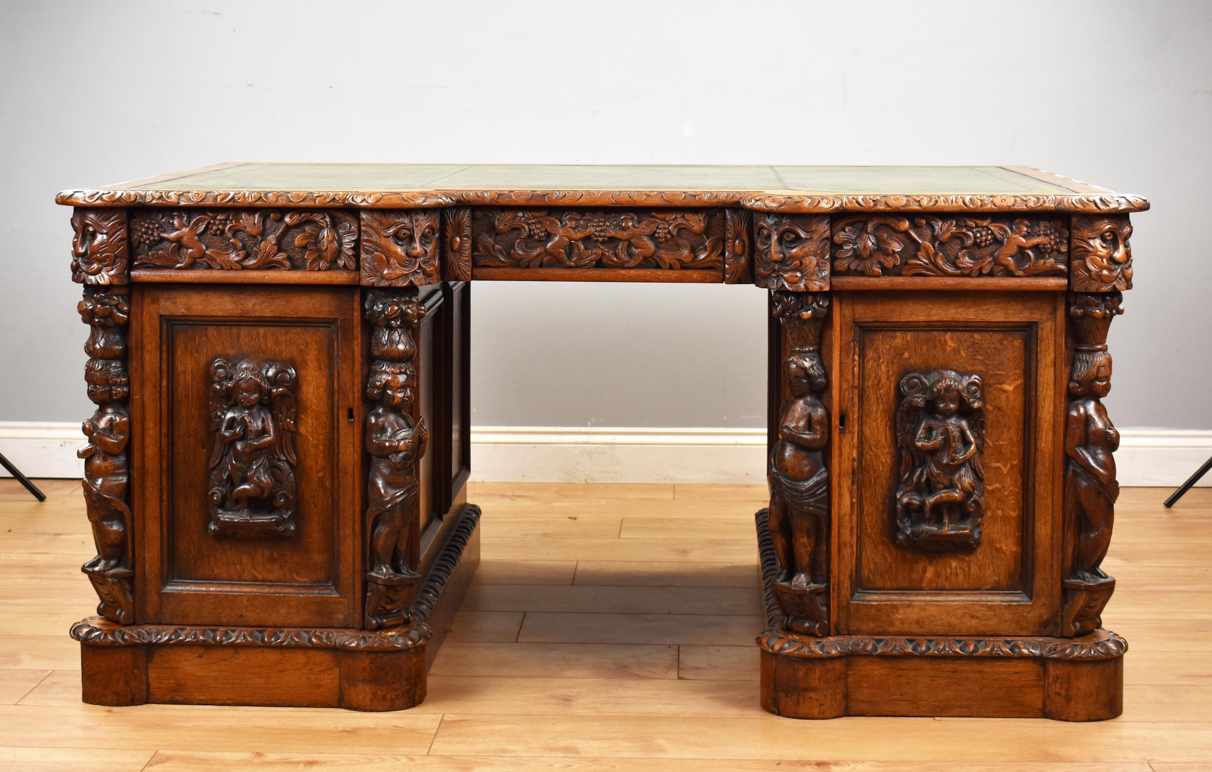 A good quality Victorian carved oak pedestal desk, inverted breakfront in form, the desk has inset leather top, above three intricately carved drawers. The top fits onto two pedestals, each with ornately carved cherubs, and carved panel doors,