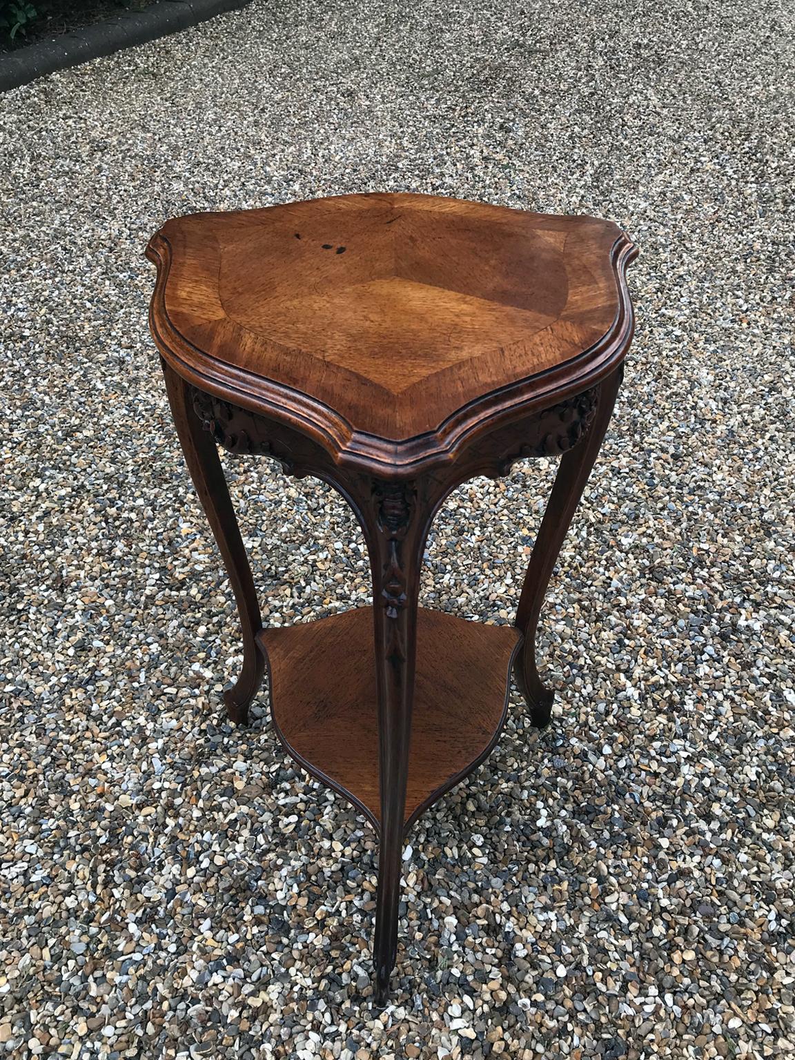19th century Victorian carved walnut shield shaped occasional table with 2 tiers, quartered veneer and crossbanded top. The apron is heavily carved with three splayed carved cabriole legs,

circa 1880

Dimensions:
Height: 27.5 inches - 70