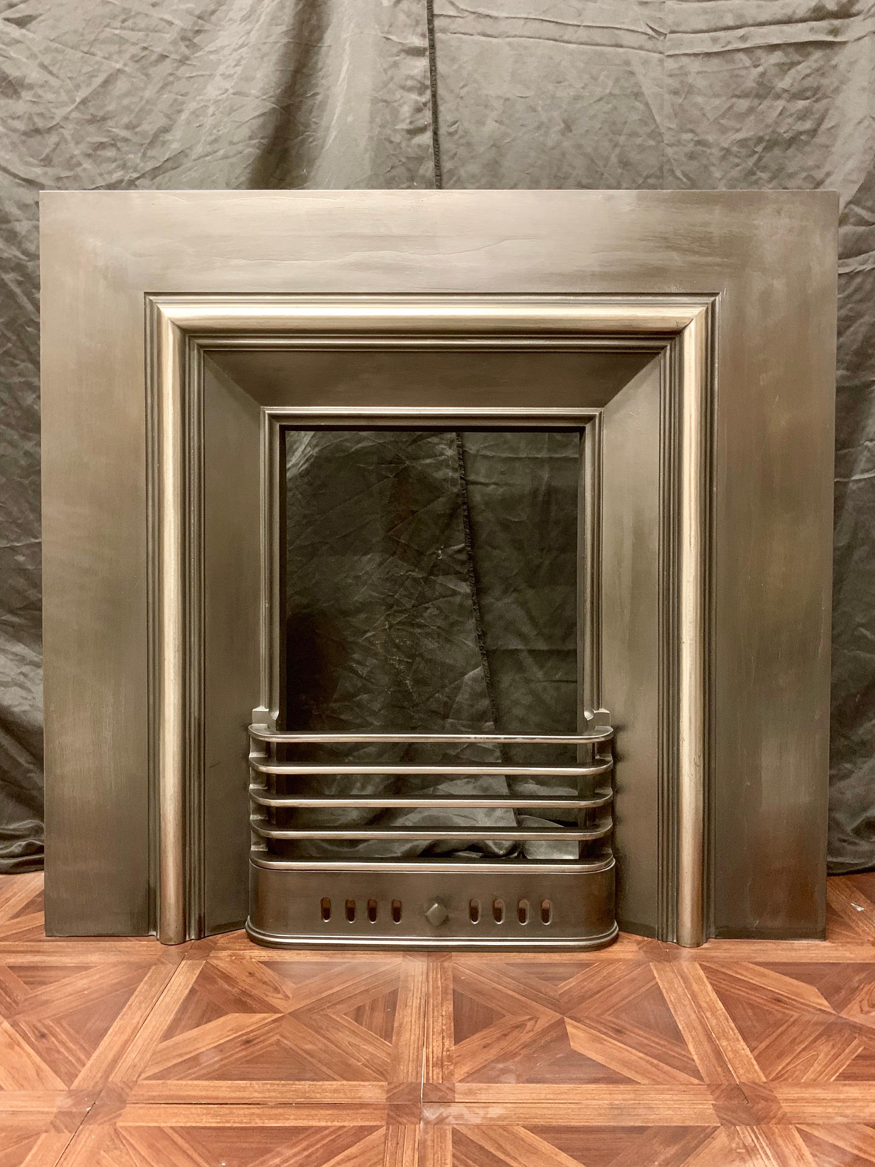 A simple and attractive generous sized 19th century Victorian cast iron fireplace insert with a polished raised moulding framing the opening aperture, with a four barred straight fire grate grill and ash pan cover, would suit a variety of fireplace