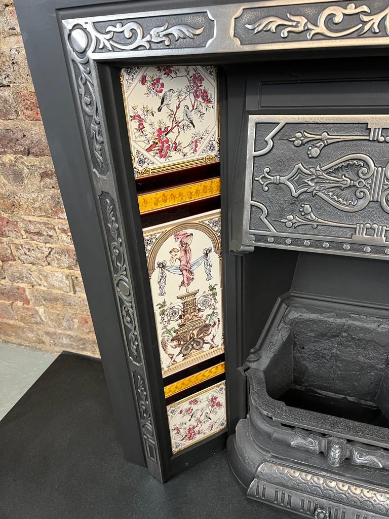 19th Century Victorian cast-iron fireplace tiled insert.
A good classic Victorian antique fireplace finished to a traditional highligh polish/ burnished finish. 
Complete with its fire back, front bars, hood, finished with a set of alexandra urn