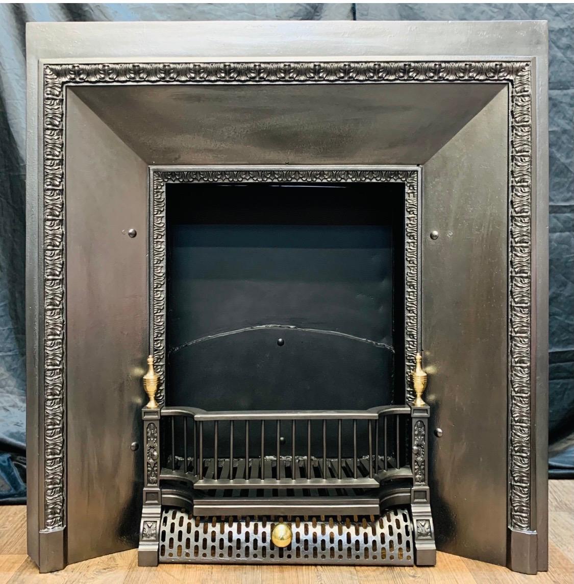 A charming mid-Victorian 19th century cast iron splayed fireplace insert of good form. An outer rim plate showing a border of embellished floral edging terminating onto shaped foot blocks, return splayed cast panels finishing onto further