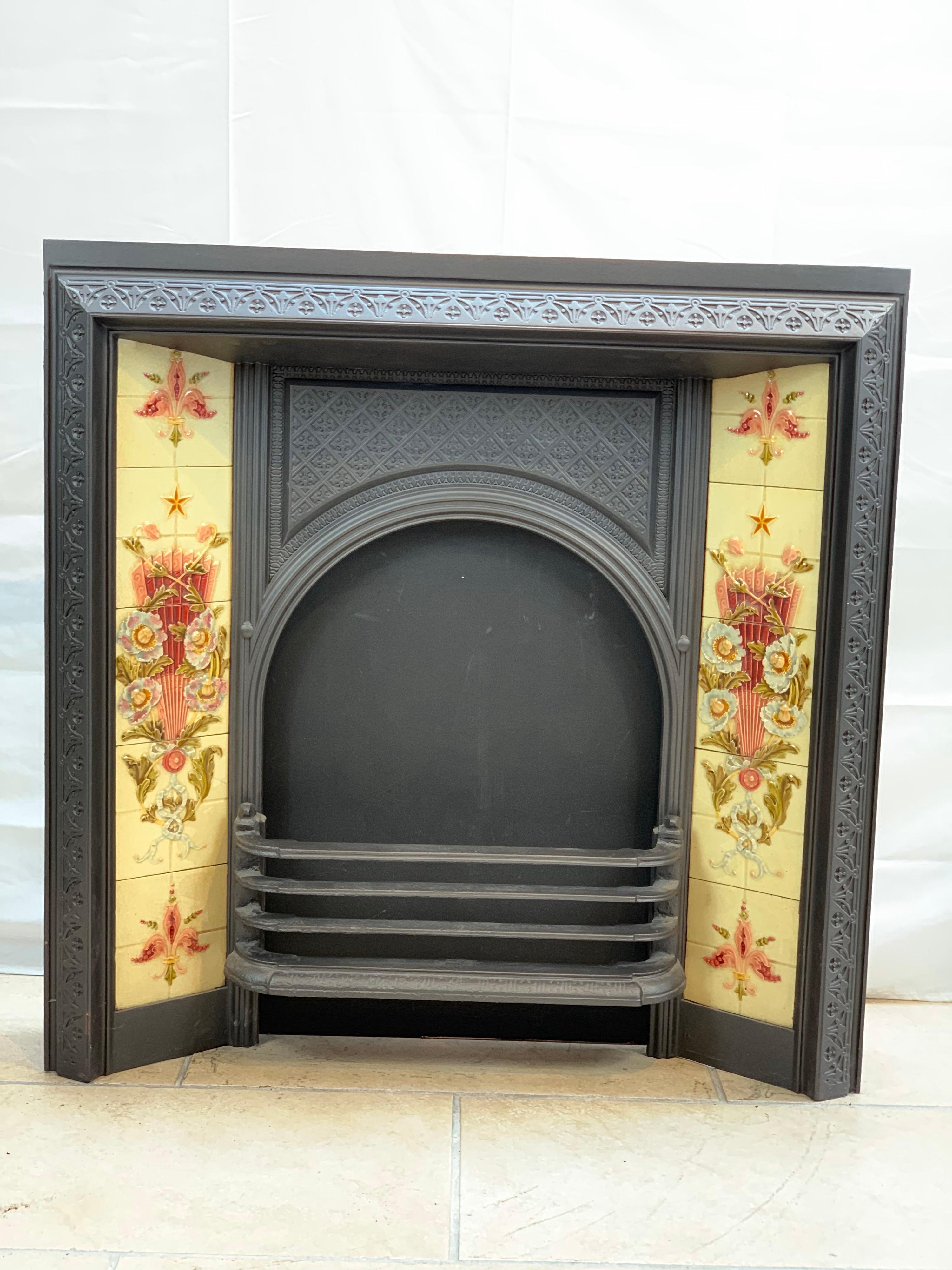 A Victorian original tiled cast iron fireplace insert with beautiful original tile panels.
