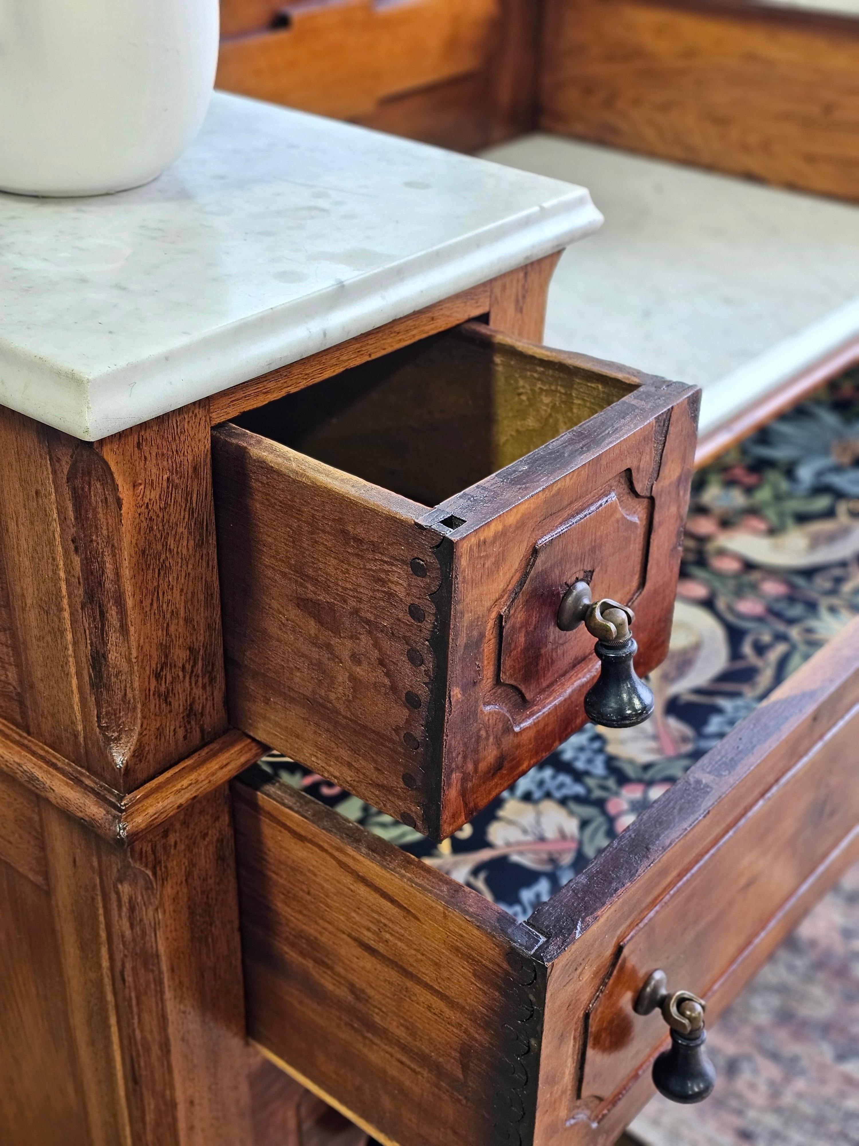 For your consideration is a rarely found Victorian era American chestnut dresser with Carrara marble slabs and original teardrop drawer pulls.

This rare Victorian dresser, crafted from solid American chestnut with decorative veneer facings, is a