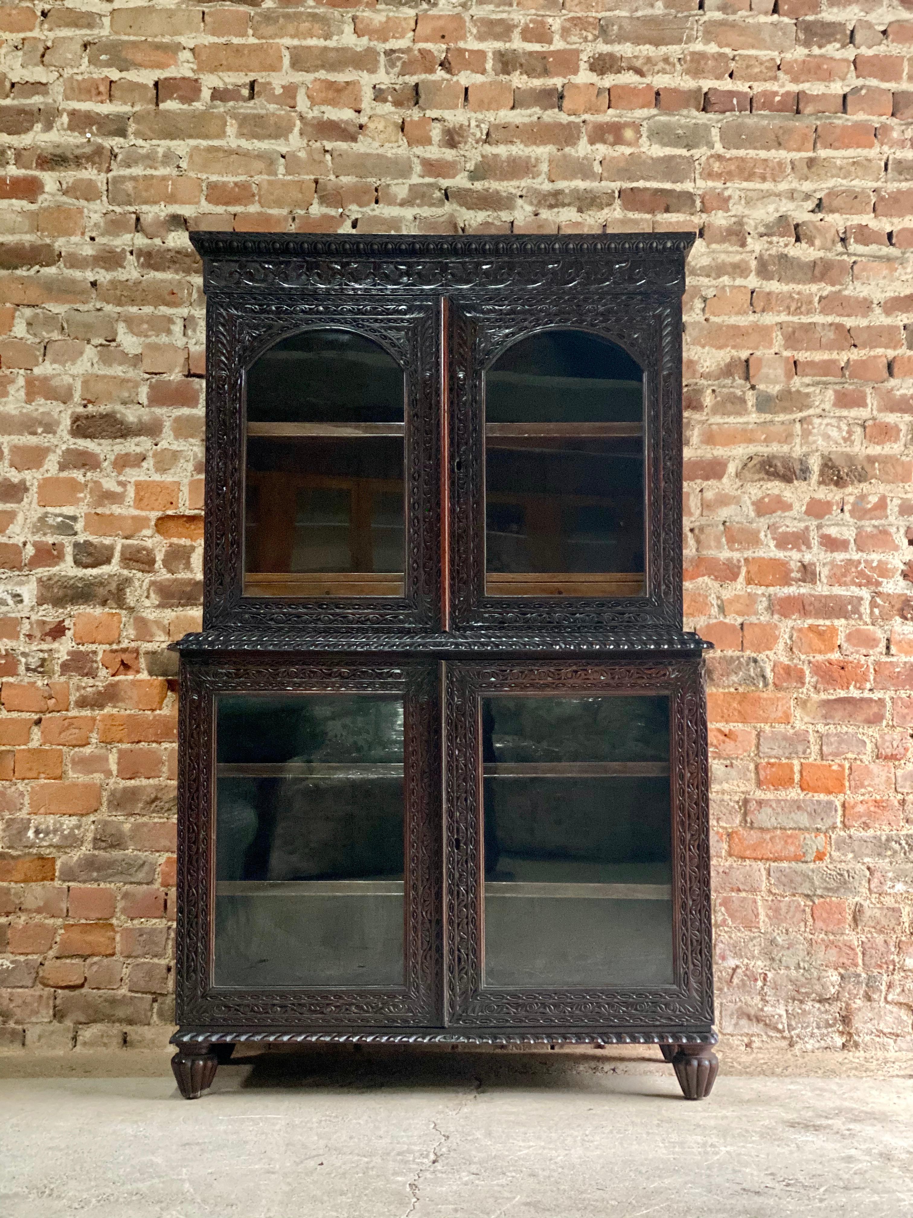 19th century Victorian colonial Anglo-Indian Padouk bookcase, circa 1890

Impressive 19th century Victorian colonial Anglo-Indian Padouk four-door bookcase circa 1890, the ornately carved cornice over a pair of arched glazed doors enclosing a