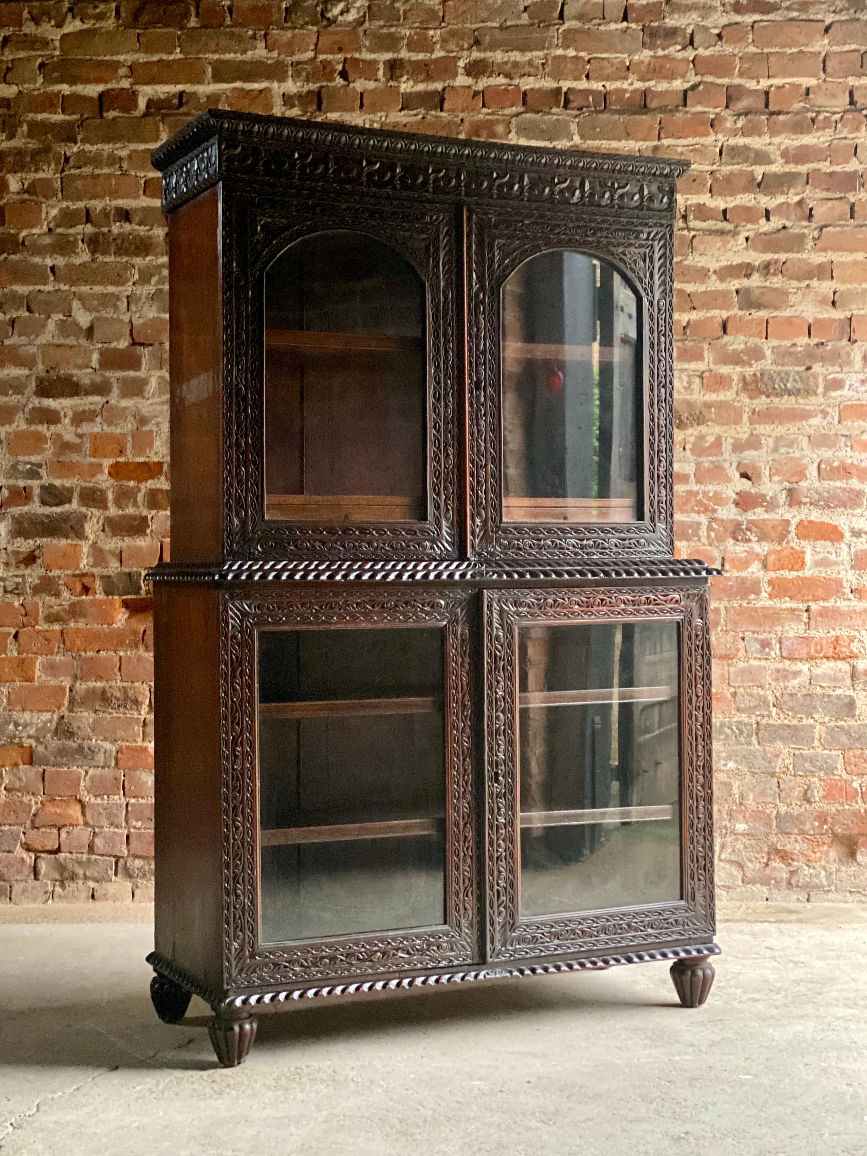 19th century Victorian colonial Anglo-Indian Padouk bookcase, circa 1890

Impressive 19th century Victorian colonial Anglo-Indian Padouk four-door bookcase circa 1890, the ornately carved cornice over a pair of arched glazed doors enclosing a
