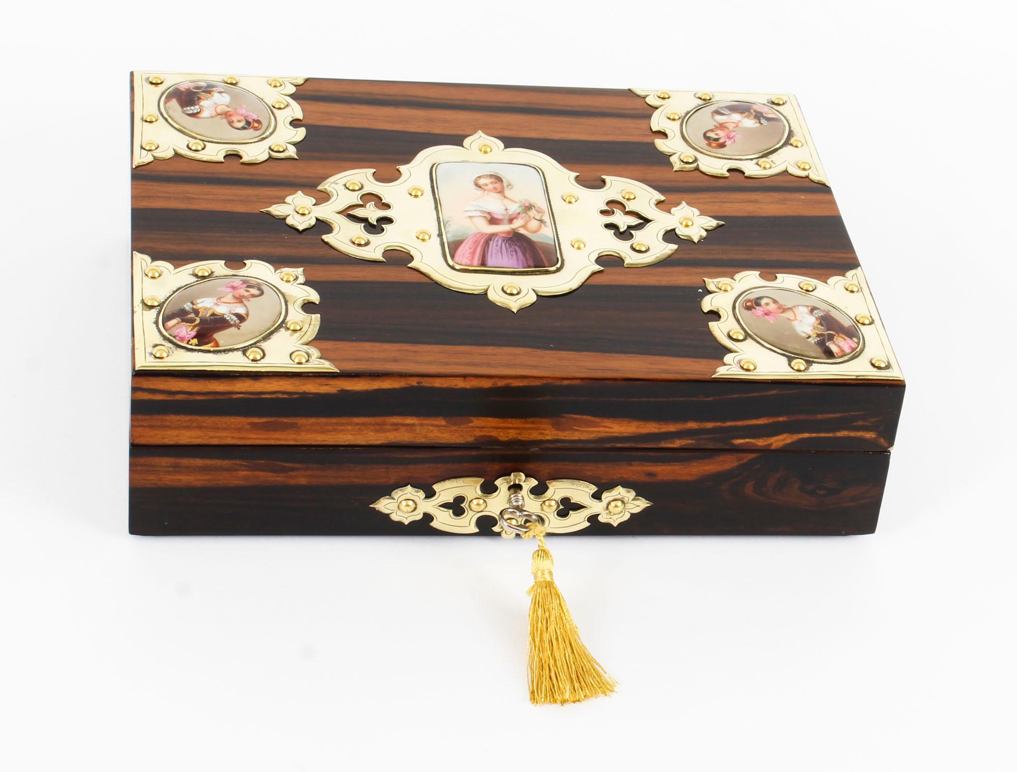 This is a beautiful antique English Victorian coromandel jewellery casket, circa 1880 in date.

The casket lid features five decorative cut brass Neo Gothic mounts containing KPM porcelain plaques depicting classical maidens, and a striking cut