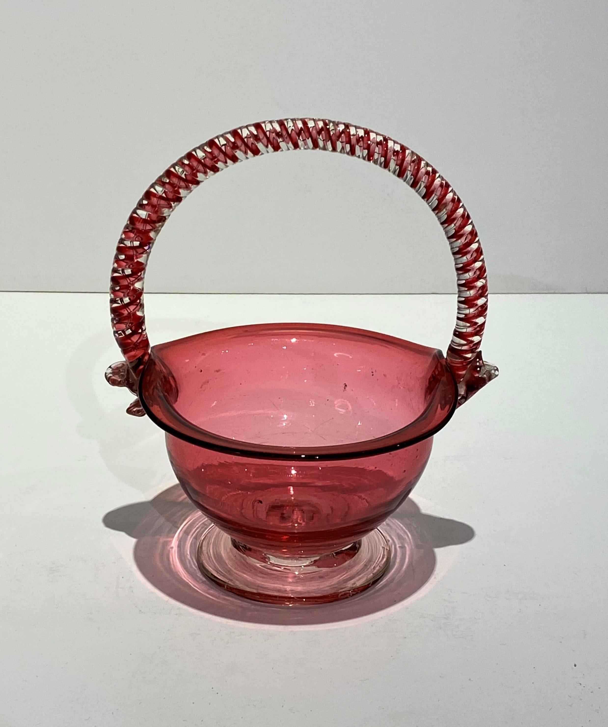 Raffinato cestino in vetro di mirtillo rosso di produzione inglese del XIX secolo con manico a spirale.  Circa 1850.