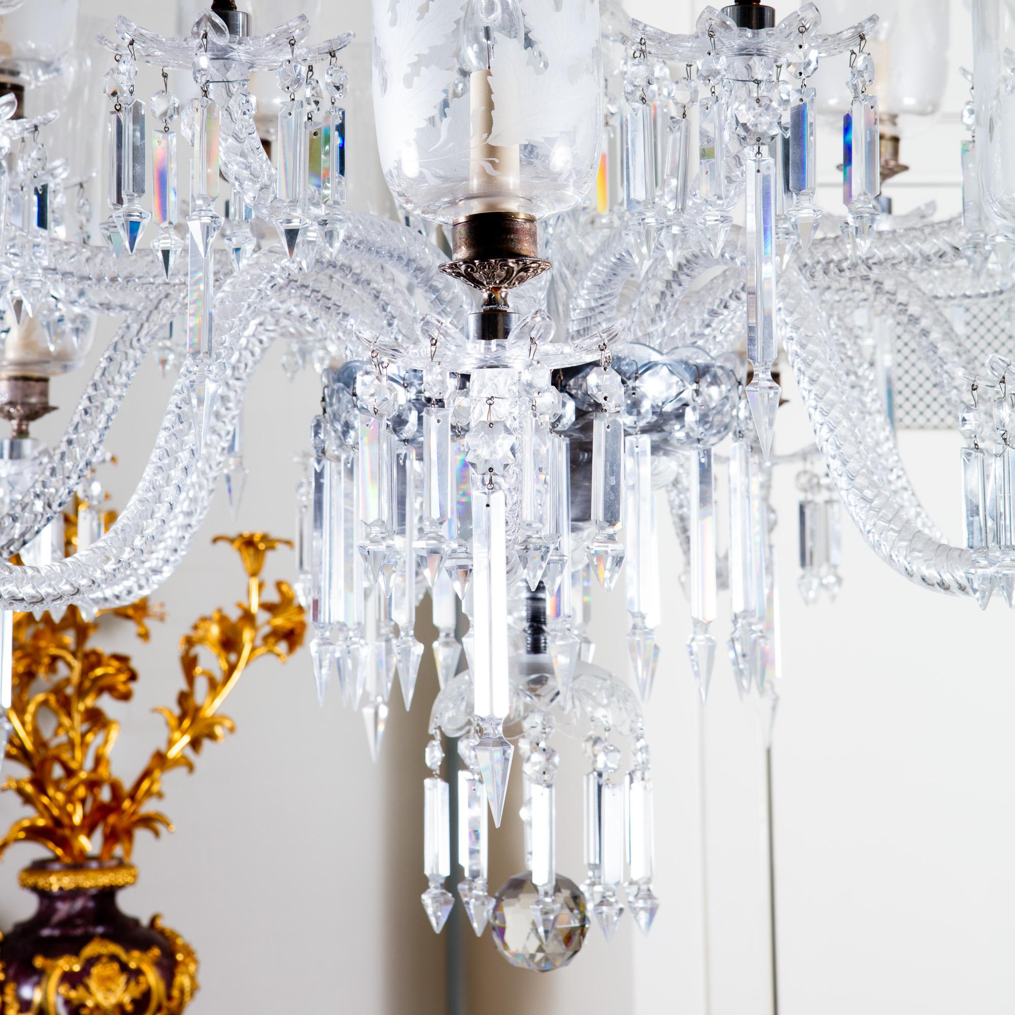 A fine late 19th century clear cut lead crystal glass chandelier, the central shaft with a central sphere between baluster sections, all cut, above a corona festoon of scrolled facet cut arms suspending pear drops and an inner ring suspending Albert