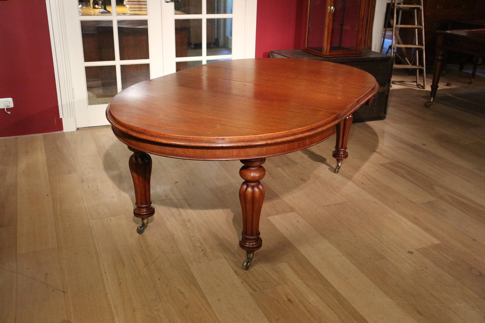Beautiful antique oval mahogany dining room table with 2 original intermediate leaves. The table is in completely original condition. Stands on brass wheels. The table is low as is the case with many antique tables from the Victorian era. However,