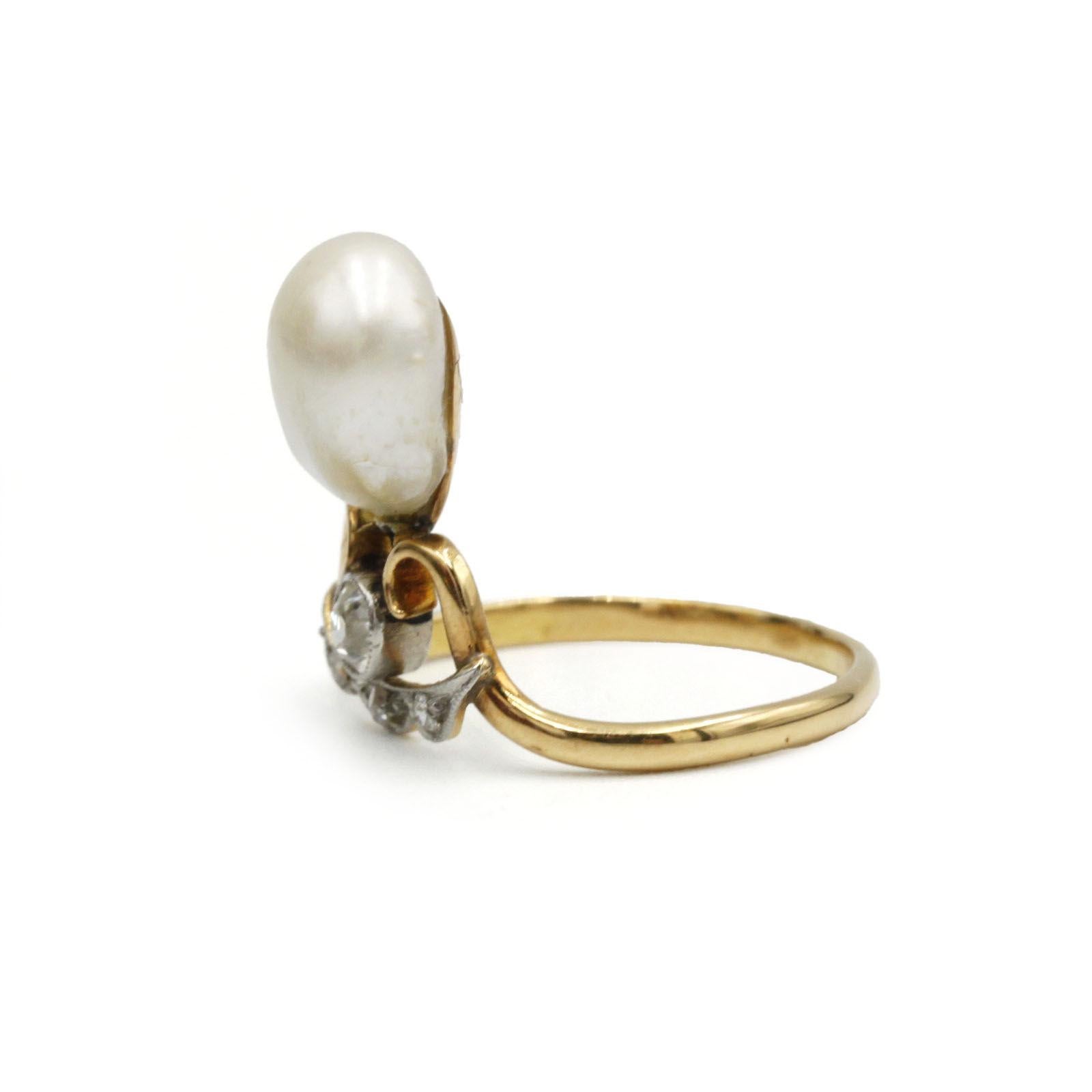 Rich with period character, this 19th Century Victorian “Duchess” ring features a luminous baroque pearl set above an old-cut diamond (~0.10 ct) flanked by delicate rose-cut diamond accents. Crafted in warm 18 K yellow gold (750‰), its sinuous