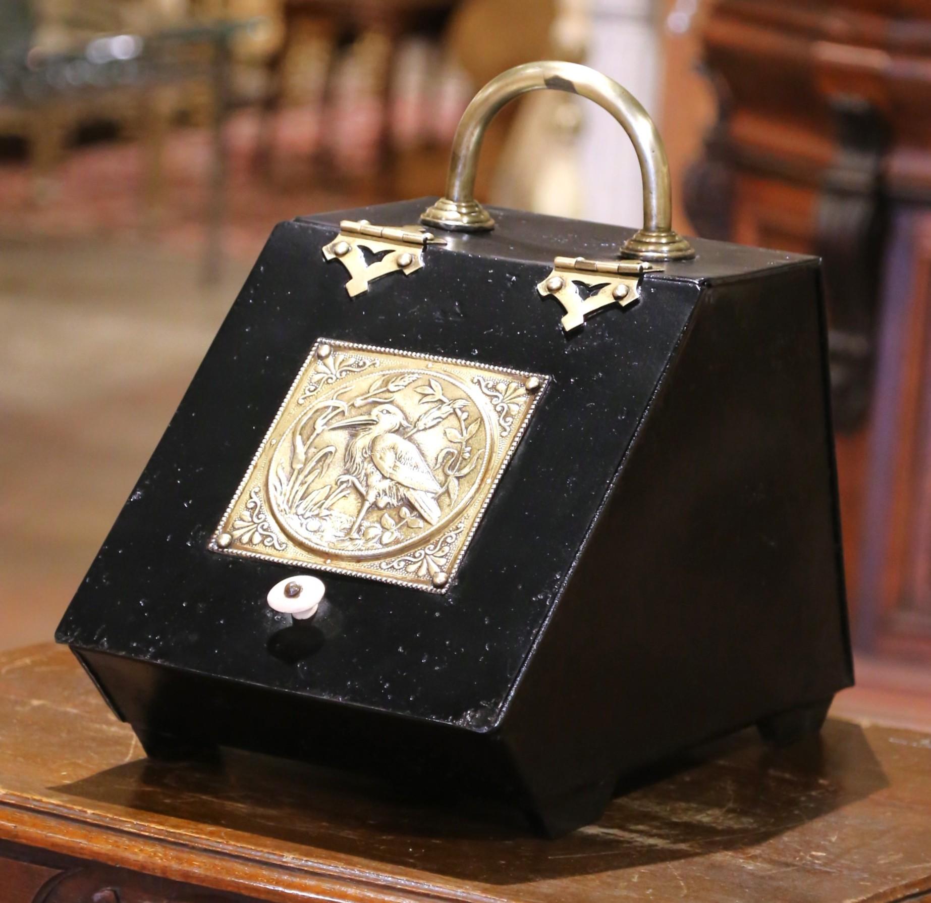 Esta antigua carbonera inglesa data de finales del siglo XIX y es un ejemplo de la artesanía toleera victoriana. Construida en metal pintado de negro, la papelera presenta una forma trapezoidal inclinada con una tapa abatible operable, acentuada por