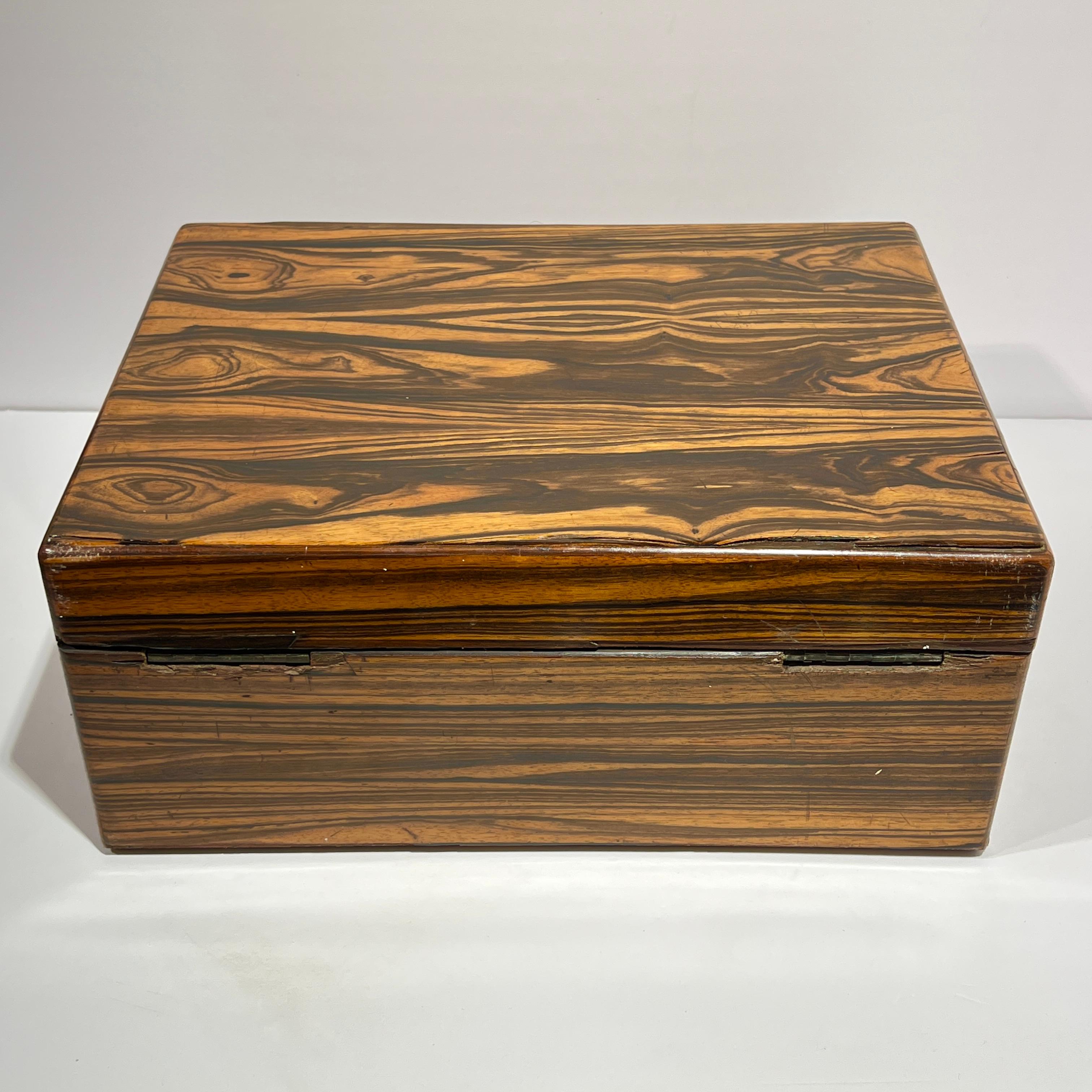 Coffre de campagne anglais ancien (19e siècle) en ébène ou en bois de coromandel avec poignées en laiton encastrées, intérieur doublé et tiroir coulissant.  15 1/2 par 12 par 6 pouces.  Avec des serrures de la société Bramah de Londres.