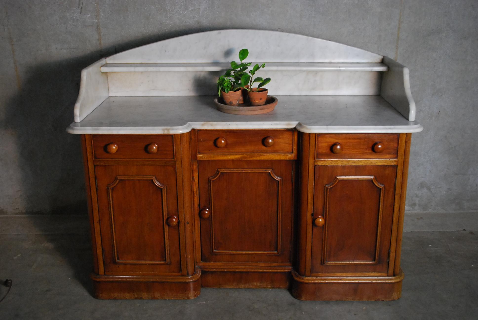 Beautiful untouched piece with multiple doors, unbroken marble top, in old finish solid mahogany.
Piece has unusual 3 door configuration with scalloped marble stone.
Acquired from a private collection.
  