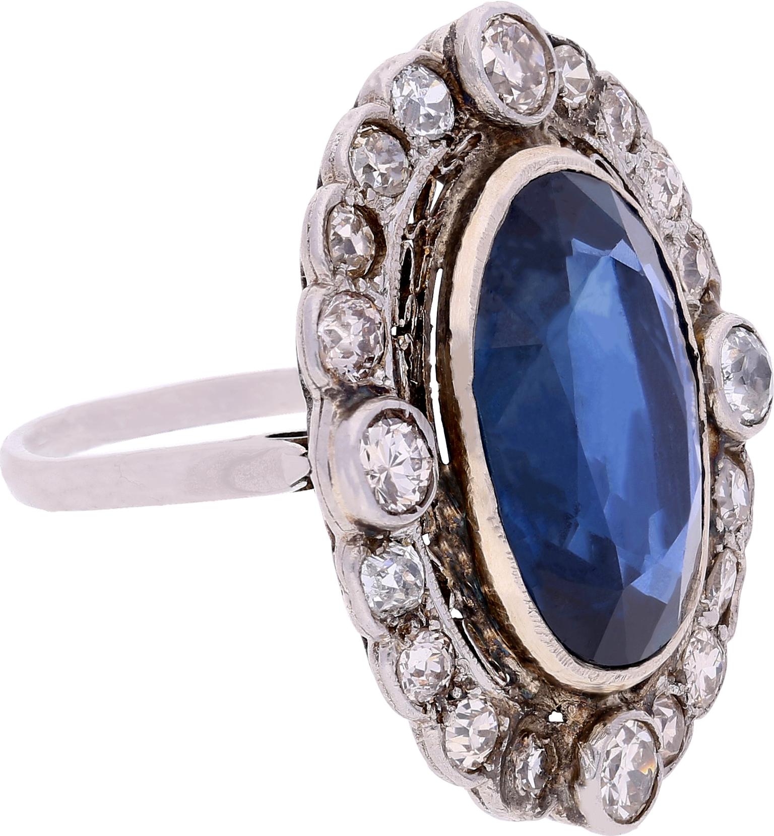 Centrée sur un saphir de Birmanie non chauffé d'environ 15 carats (selon AGL - American Gem Laboratory), encadrée par des diamants de taille européenne pesant 11,02 carats, et sertie dans du platine et de l'argent, cette bague en saphir de l'ère