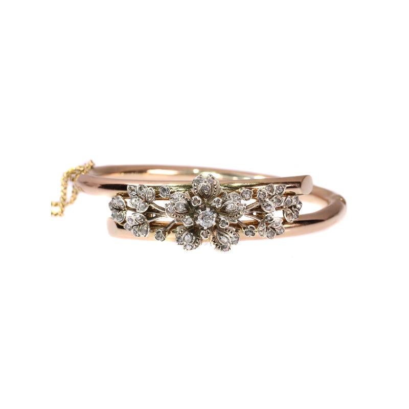 A fine 19th century Victorian antique bangle with flower motifs in 18 karat rose gold and silver, set with one old European cut diamond weighting .17 carat (colour and clarity: I/J, i) and 54 rose cut diamonds. Circumference of inside bangle is