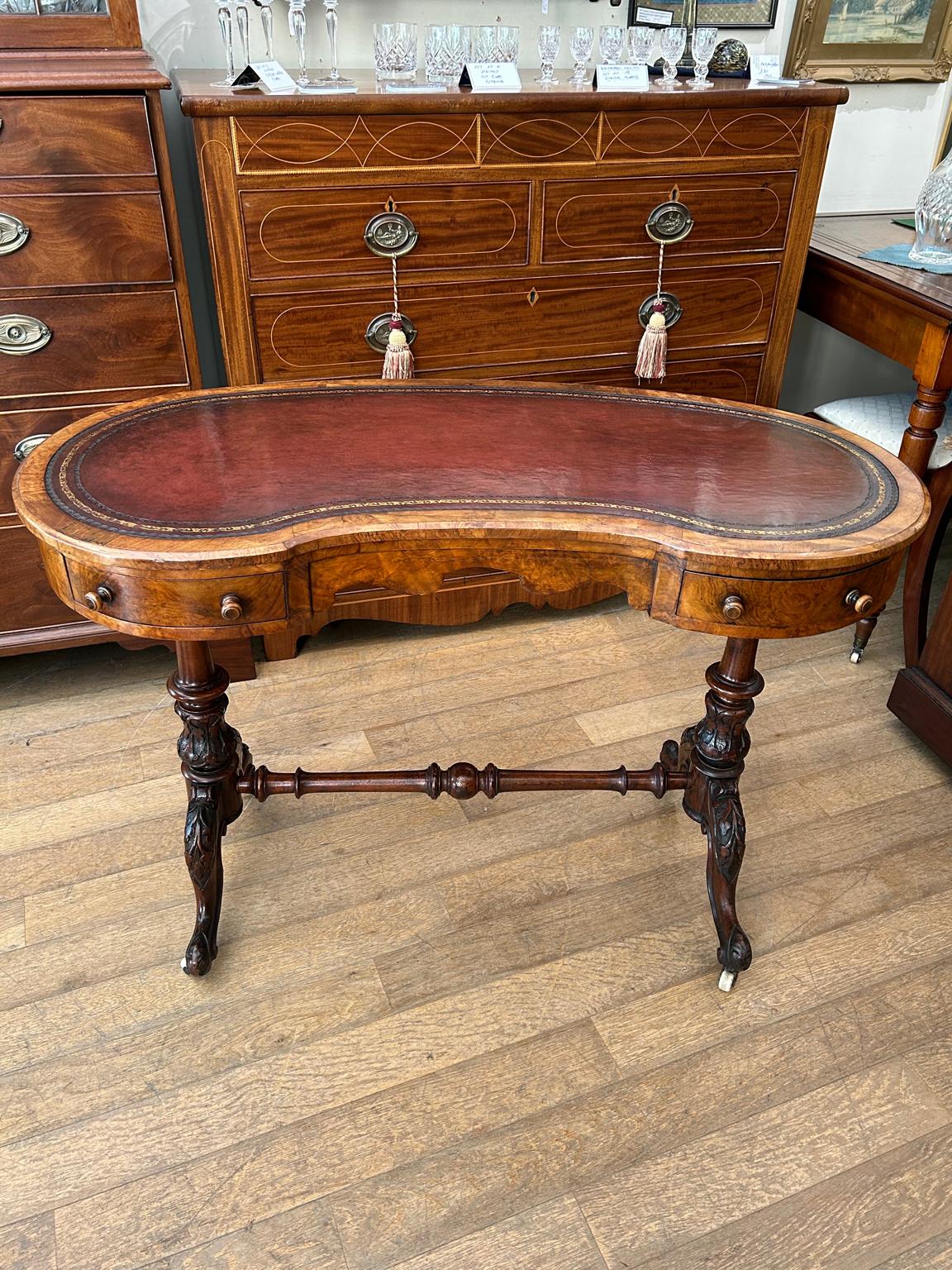 A very good quality 19th Century Victorian Figured Walnut Kidney shaped Writing Table, the top inset with a tooled leather top over two drawers. The turned supports are in solid walnut with finely carved decoration to the lower turnings. The