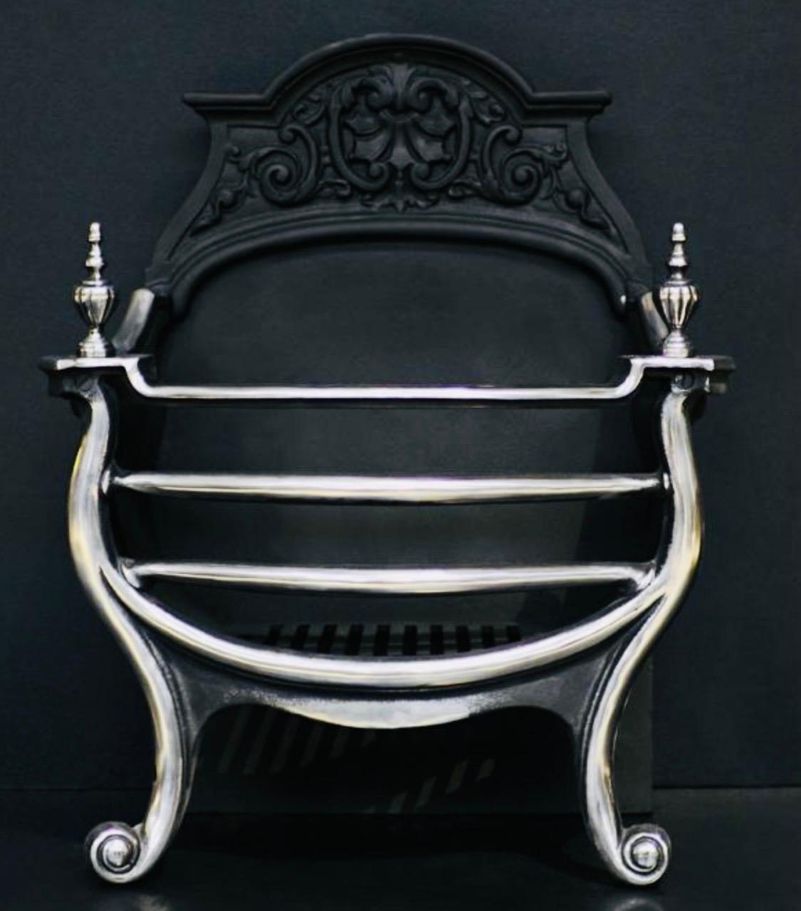 A simple 19th century Victorian polished fire grate. A shaped cast back plate with scallop sides, a three barred polished front with scroll legs topped with polished brass gadrooned urn finials. 

English 1890c.