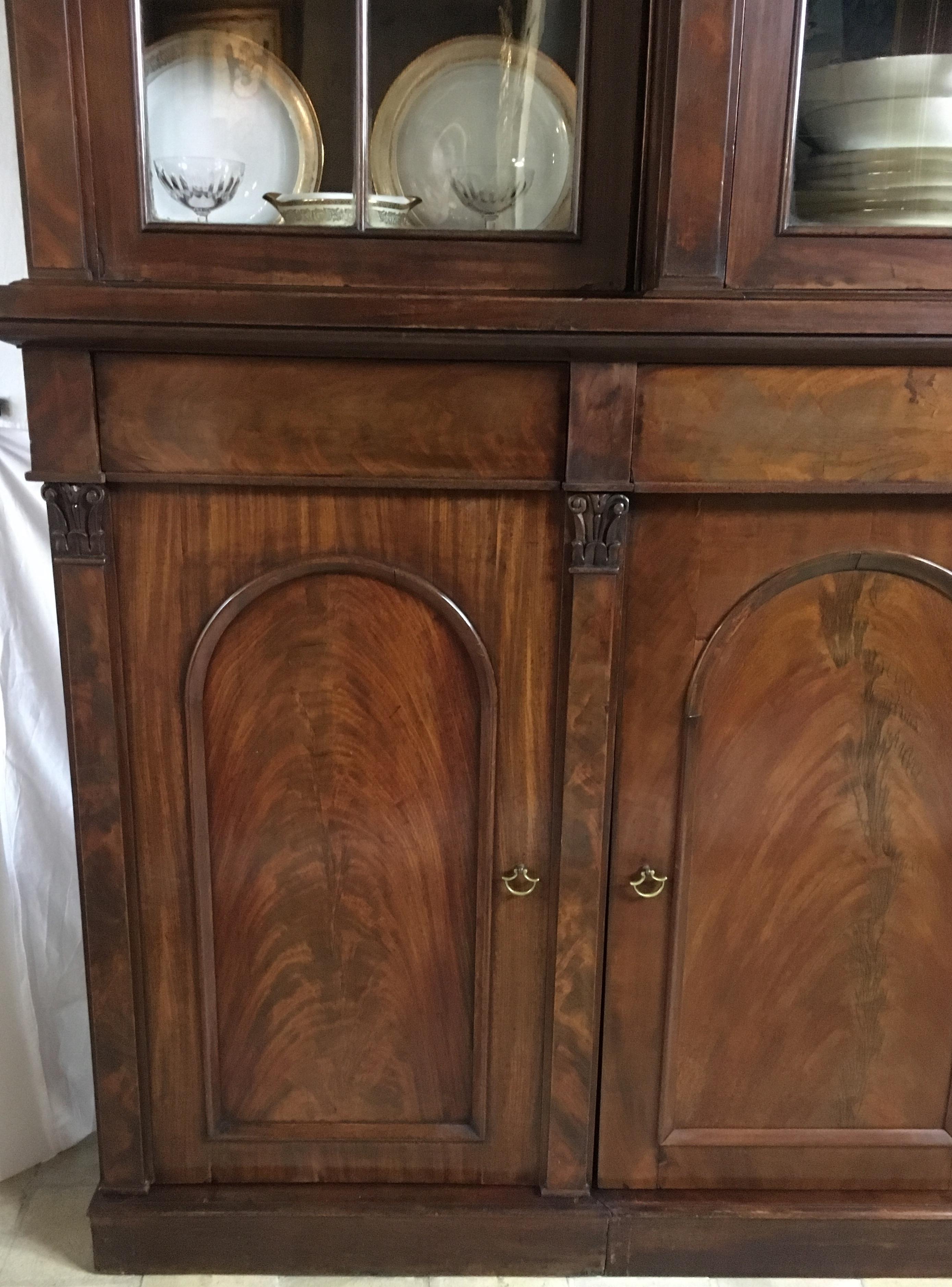 This is a beautiful antique early Victorian flame mahogany eight-door breakfront bookcase, cupboard, wardrobe or storage cabinet masterfully crafted in high quality flame mahogany wood, circa 1860.

This beautiful piece features four arched top