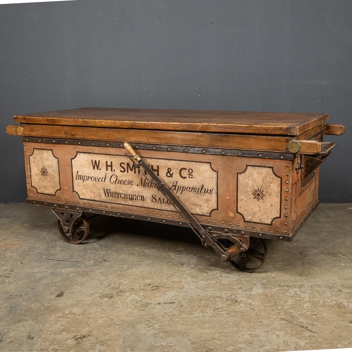 Antiker viktorianischer Güterwagen aus dem 19. Jahrhundert, der für den Transport von Futtermitteln zu den örtlichen Molkereien verwendet wurde. Dieser Metallwagen hat eine massive Eichenplatte, originale Räder und einen Kipphebel, spätere