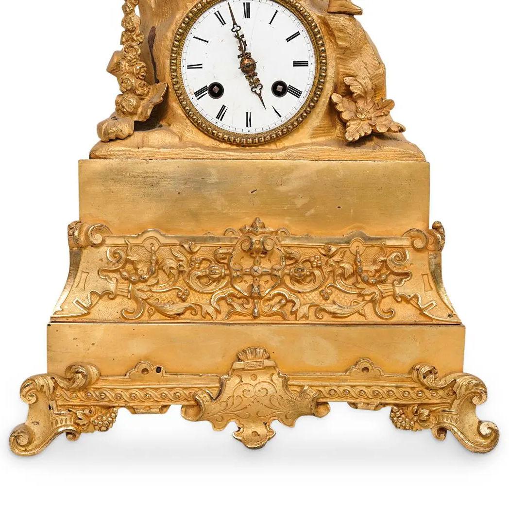 Beautiful gilt bronze mantel clock of continental original  surmounted by a lovely maiden seated on a rocky outcrop beside a basket of fruit.  Apparently unsigned.