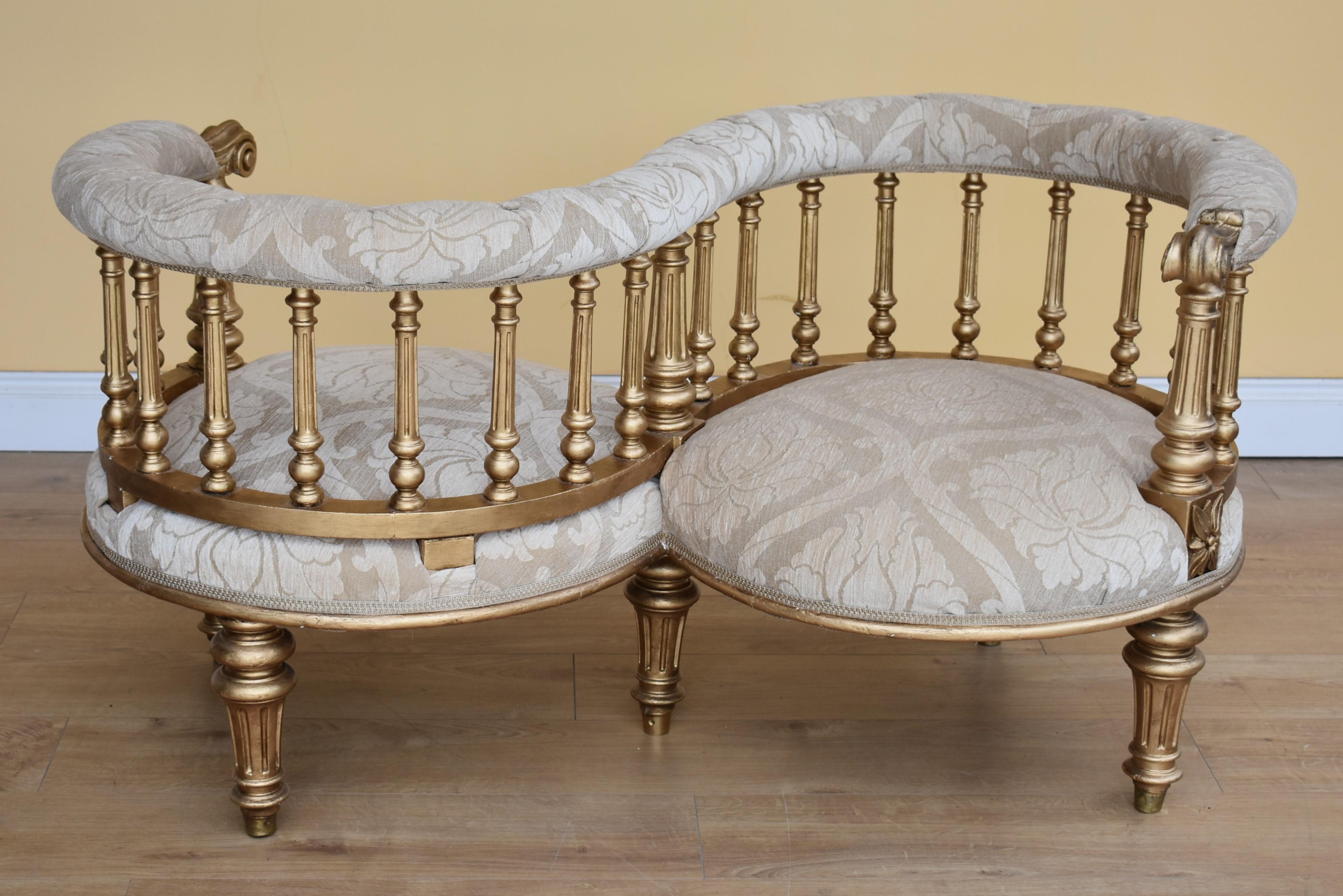 Victorian giltwood conversation seat in excellent condition having been recently upholstered and recovered in a floral fabric. The seat has nicely scrolled arms standing on turned legs.

Dimensions: Width 51