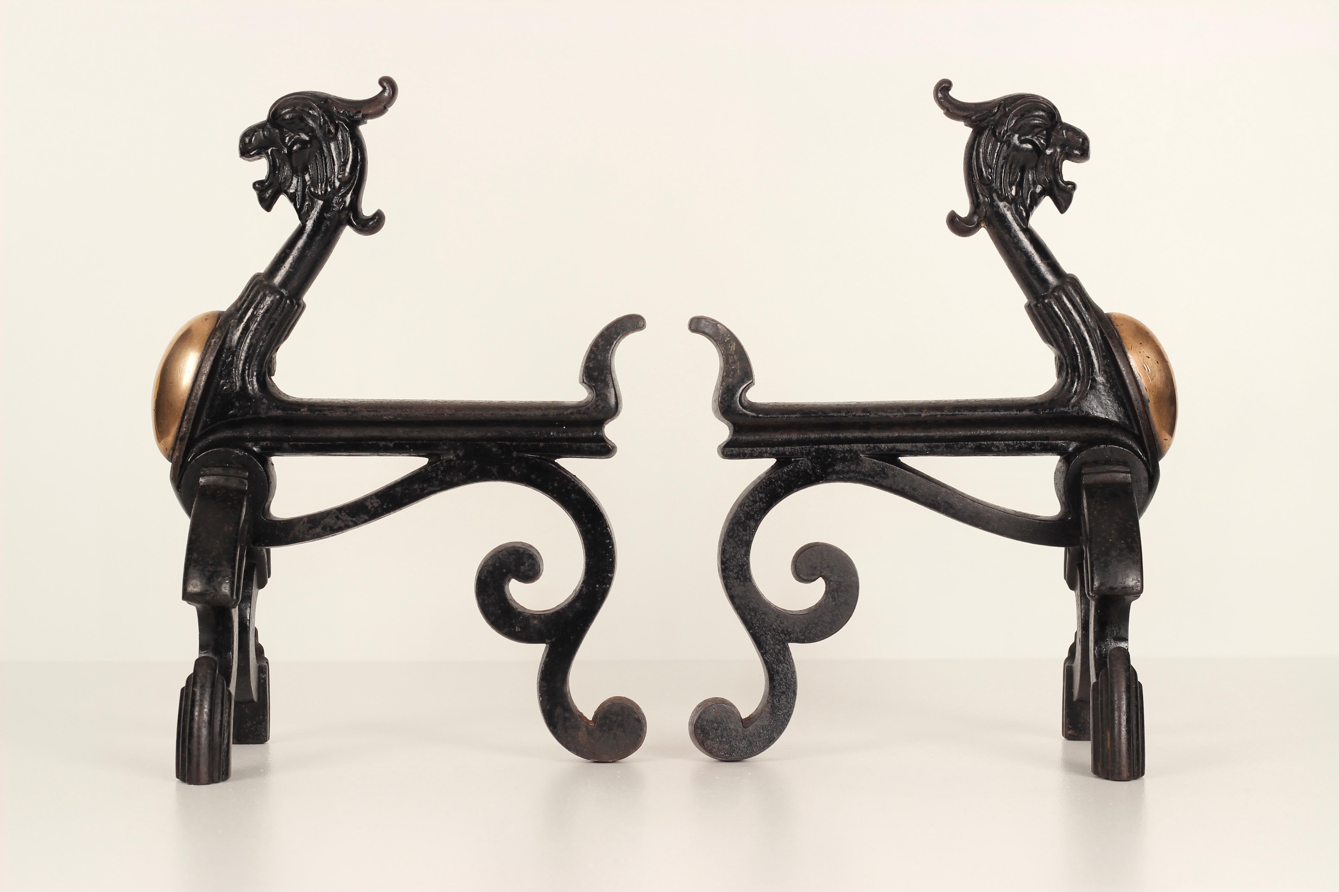 A mid 19th century pair of zoomorphic Griffin Fire Dogs or Andirons. Made from cast Iron and with copper stomach inserts, these unusual and rare pieces are indicative of the Victorian Gothic (or Victorian revivals) love of the romanticism of the
