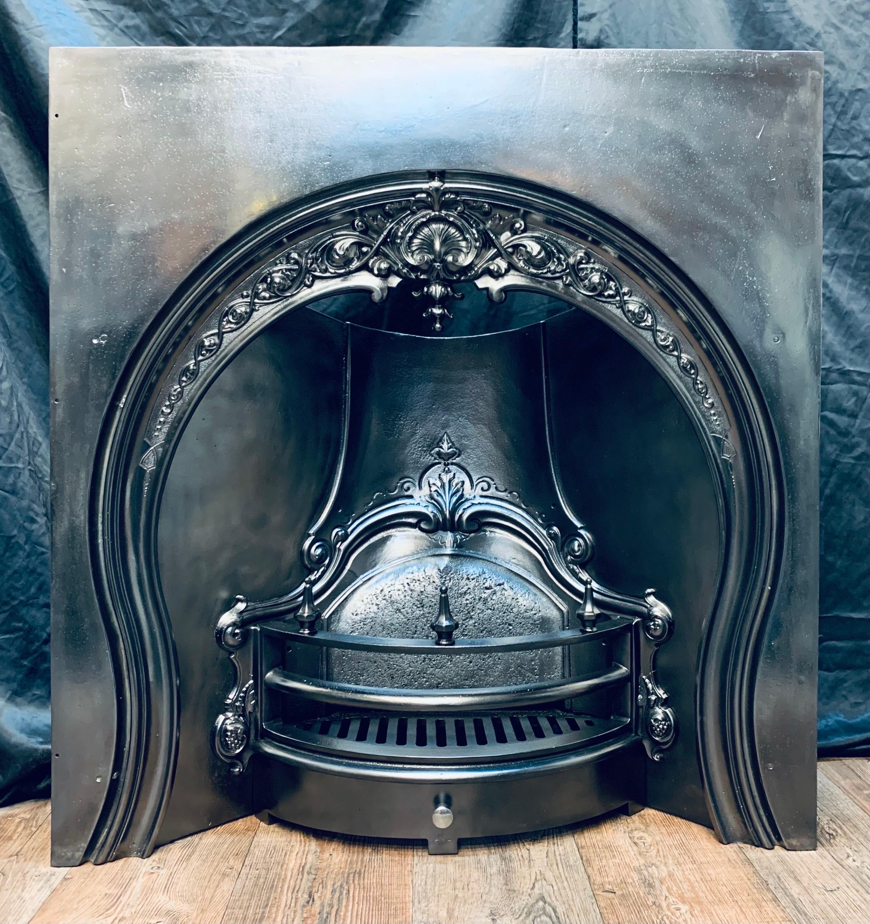 A very pleasing 19th Century Victorian cast iron fireplace insert. A generous outer plate in the form of a horseshoe shape with cast embellishments and an intricate central shell, a funnel chamber back section the three piece curved bars adorned