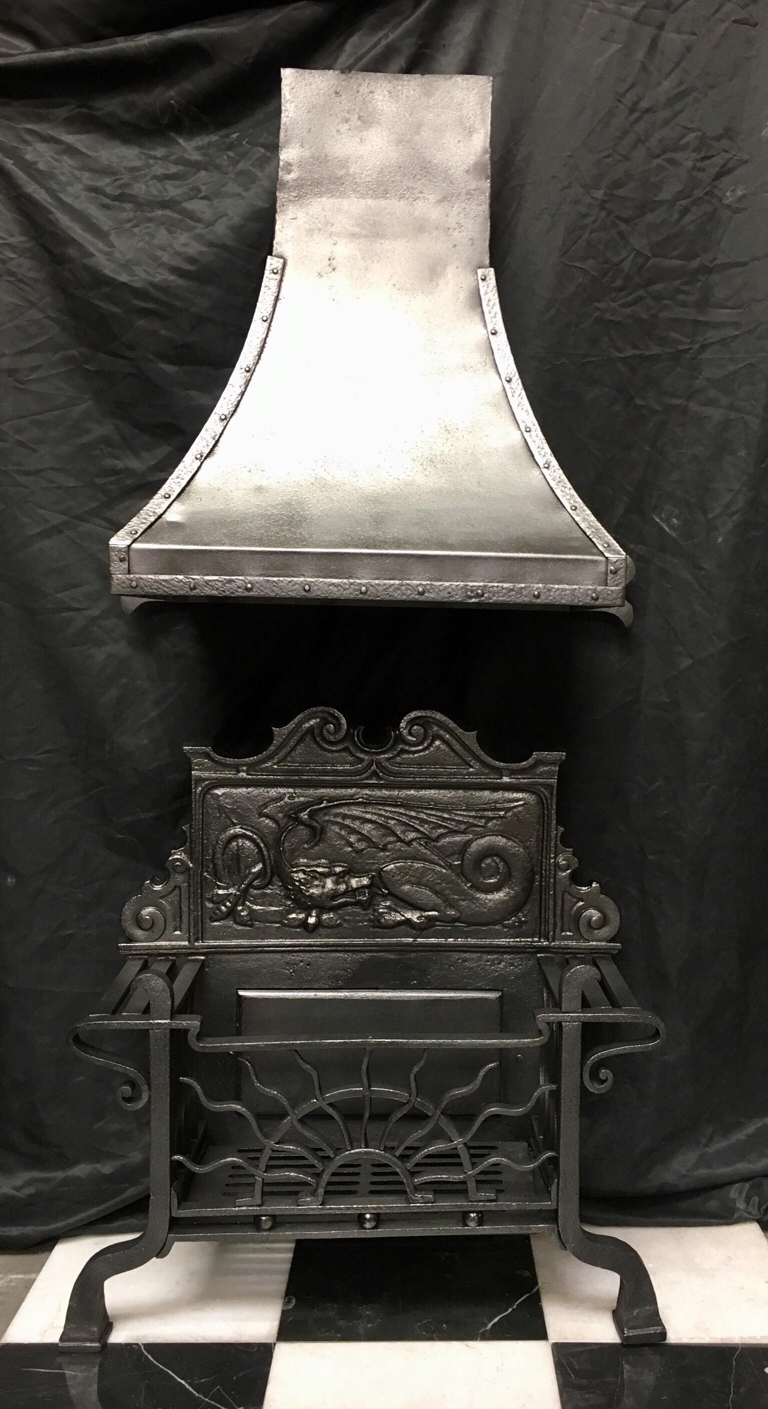 Ein originaler, antiker Feuerrostkorb aus Schmiedeeisen aus dem 19. Jahrhundert in der Aesthetic Manier mit der originalen, geschwungenen Kaminhaube. Eine hohe kartuschenförmige Feuerrückwand mit einem zentralen stilisierten Drachen in einem
