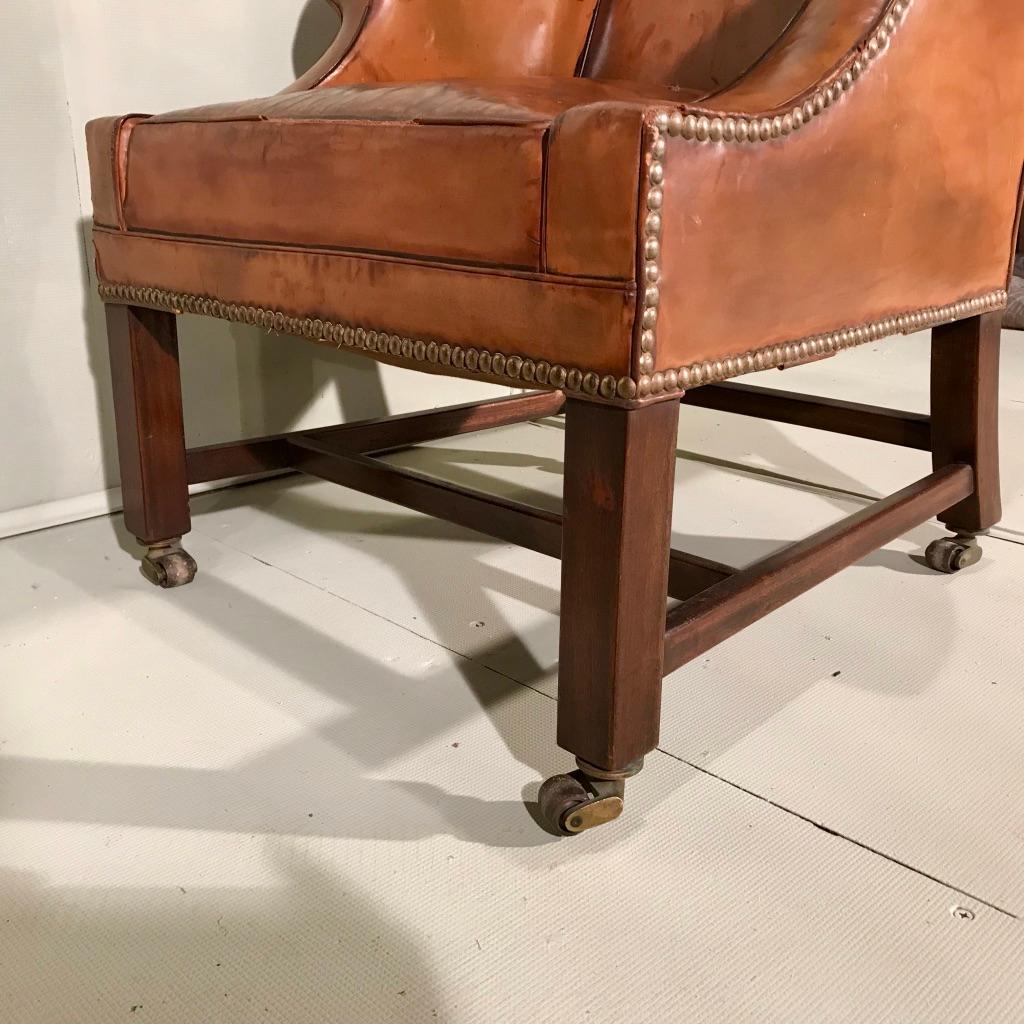 Fantastically decorative Victorian leather wing armchair, or library armchair with those beautiful swept arms and on four original brass castors.
Very comfortable chair, certainly could be used as a desk chair, or a living room everyday