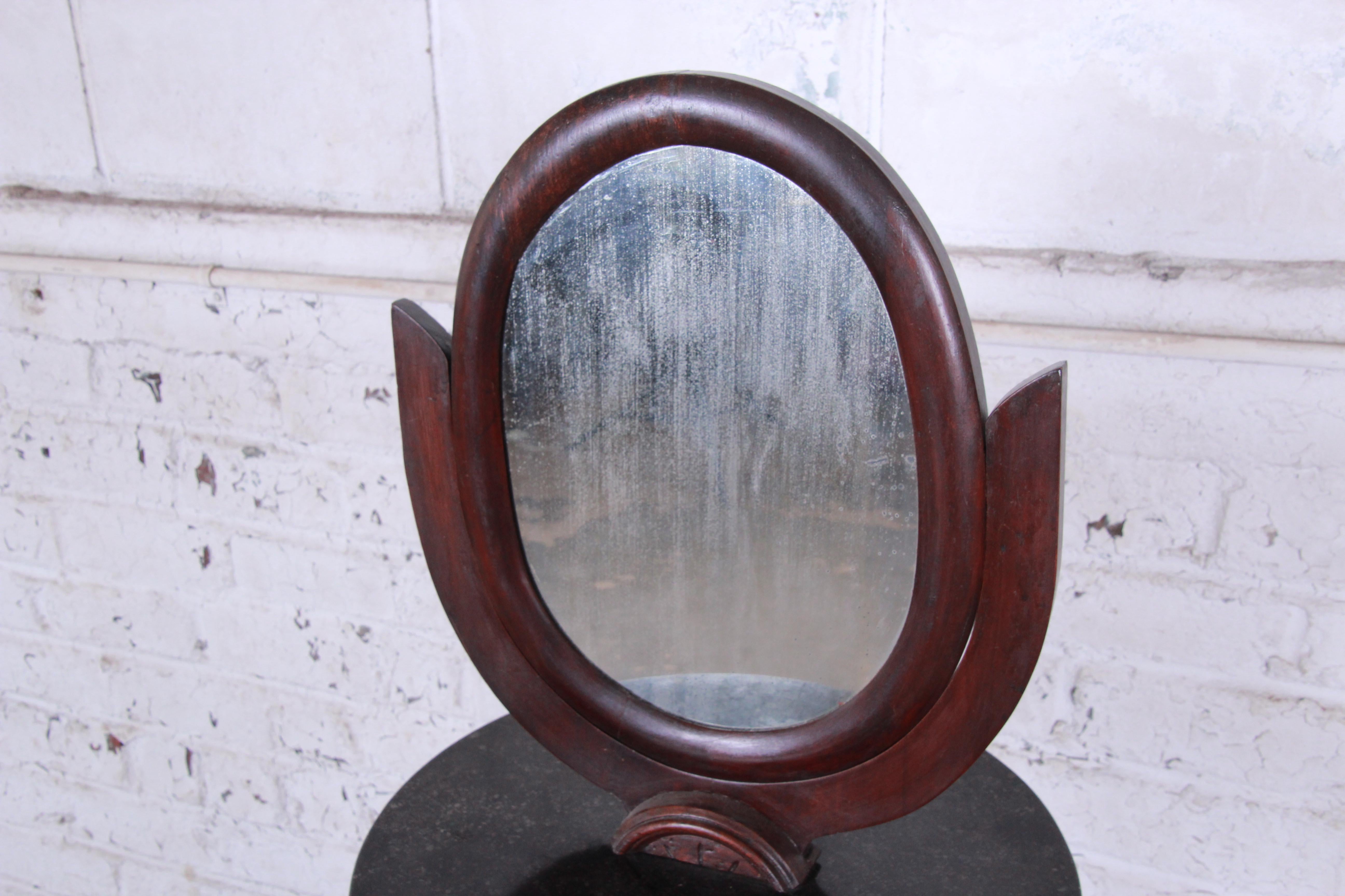 A unique 19th century Victorian mahogany mirrored shaving stand. It features an oval mirror on a round marble top with a single dovetailed drawer for storage. The stand rests on original casters. Very good original vintage condition.

The stand