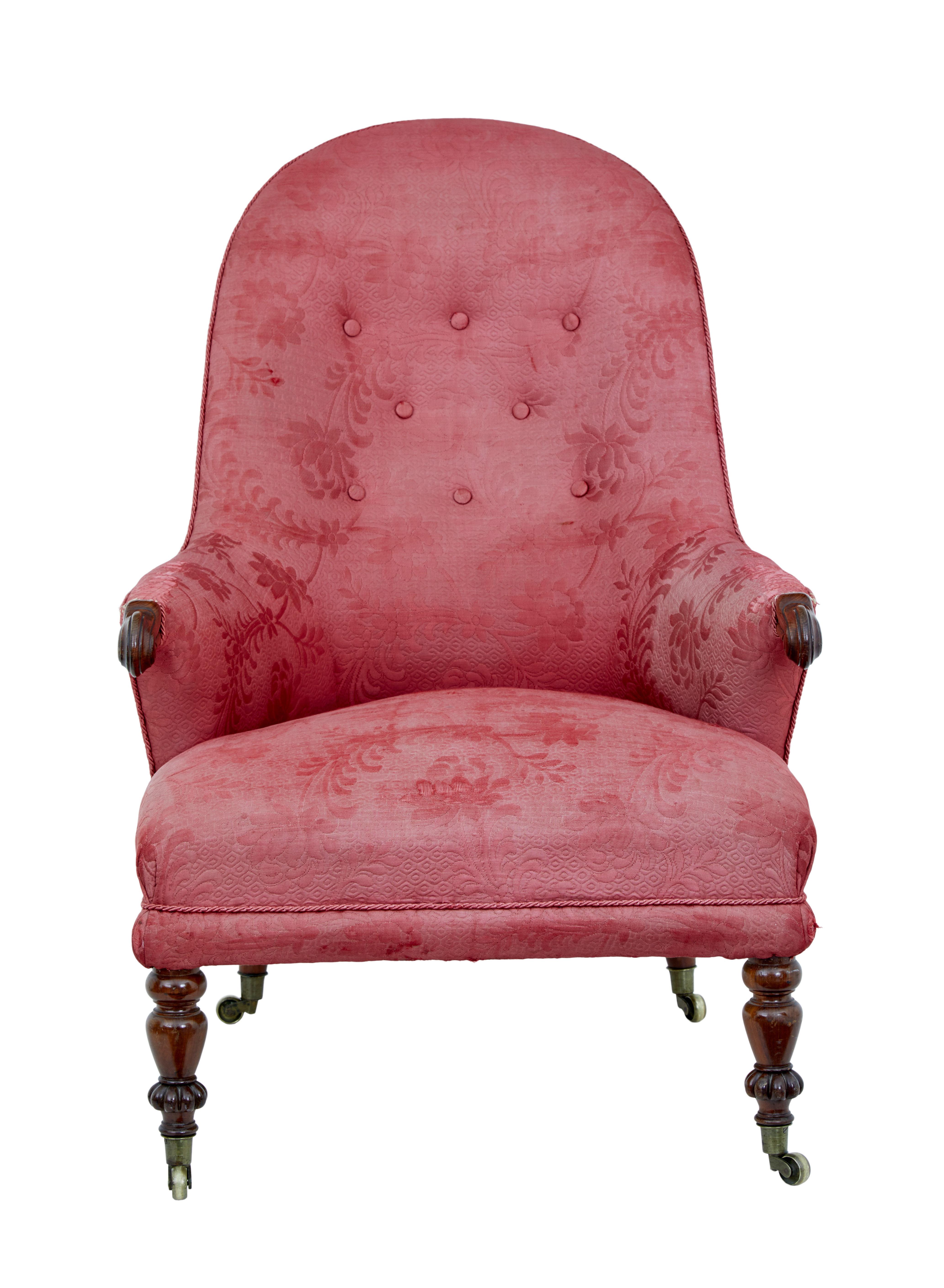 19th century Victorian shaped back armchair, circa 1890.

Arched back for comfort with button back detail. Scrolled arms and standing on front turned legs with castors.

Original fabric which is showing signs of wear to arms and seat, but in