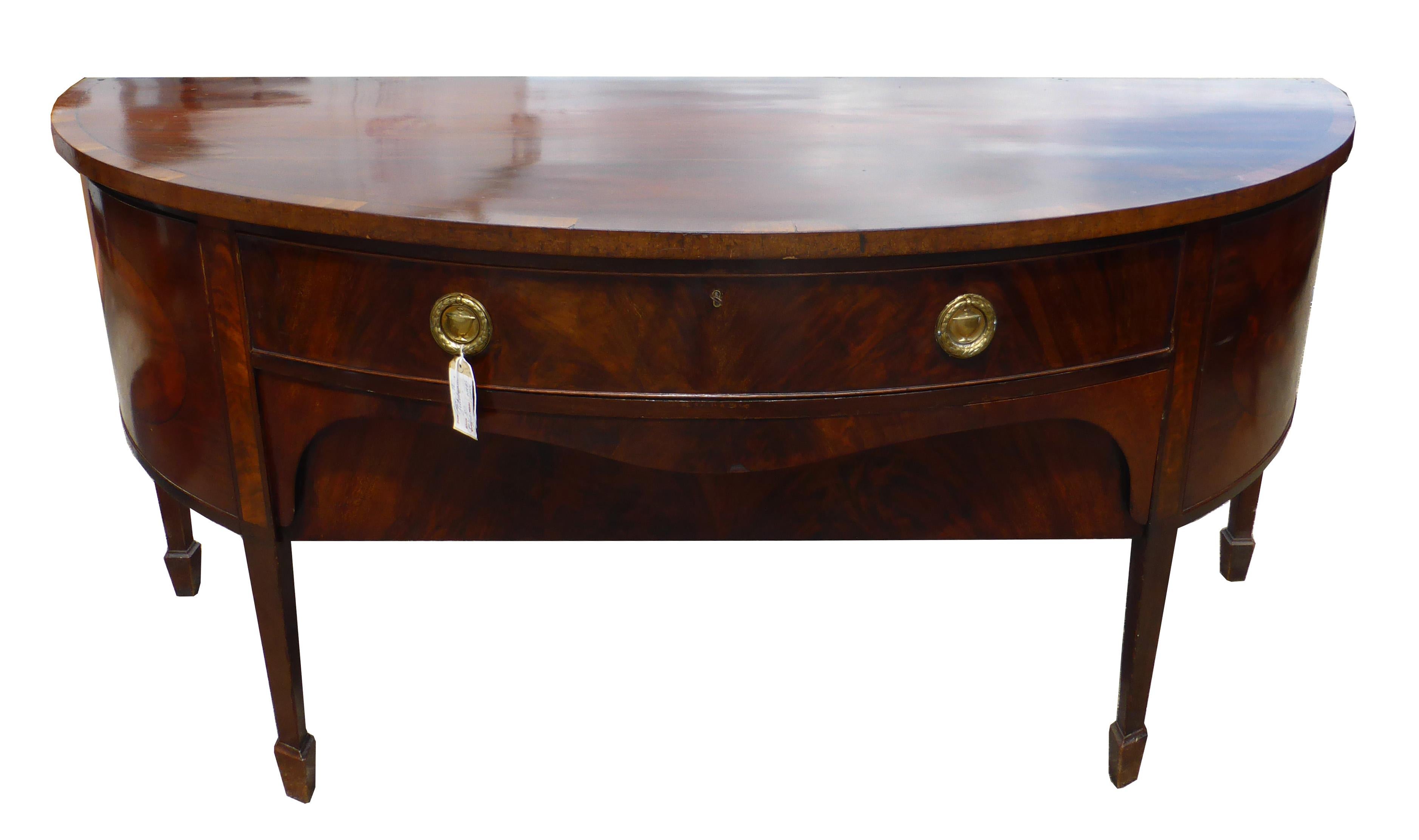 For sale is a good quality George III mahogany bow front sideboard. This piece has a large drawers to the centre, with two brass ring handles, this is flanked by two cupboards, opening to reveal ample storage space. This piece is in good condition