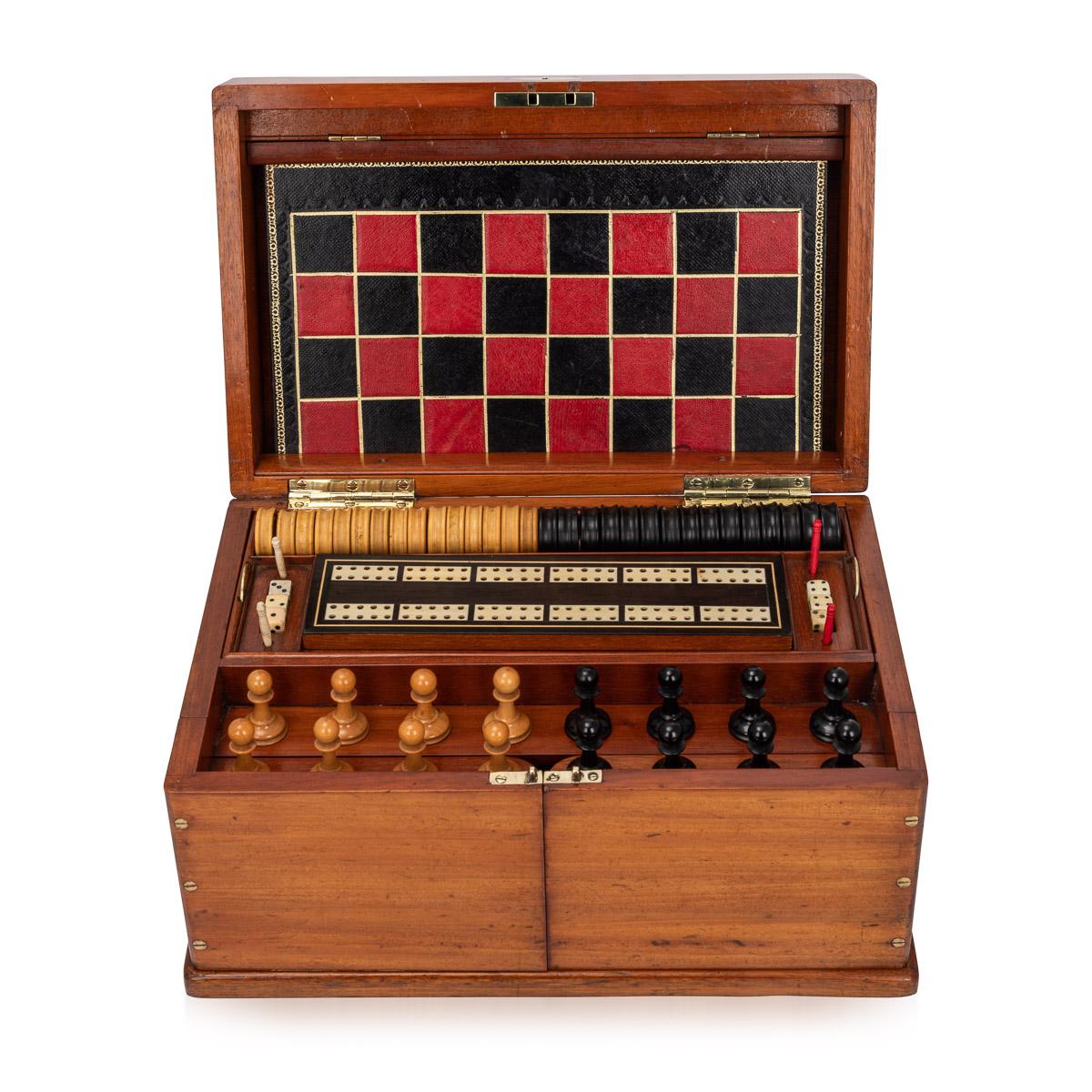 Antique late 19th century Victorian mahogany cased games compendium, the interior comprising a boxwood and ebony chess set, draughts, dominoes, dice, cribbage board with markers, leather bound boards for games, playing cards, droughts counters and a