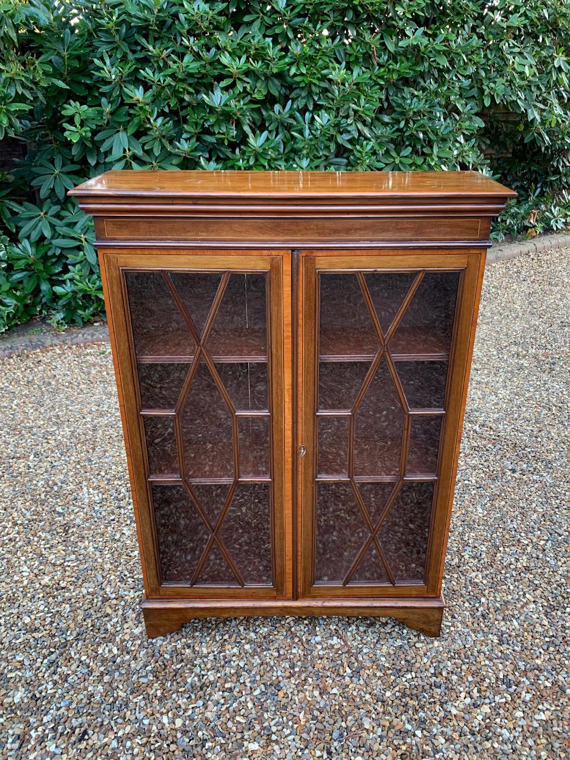 A good quality 19th century Victorian Mahogany Bookcase with three shelves, inlay, glazed doors and key on bracket feet.