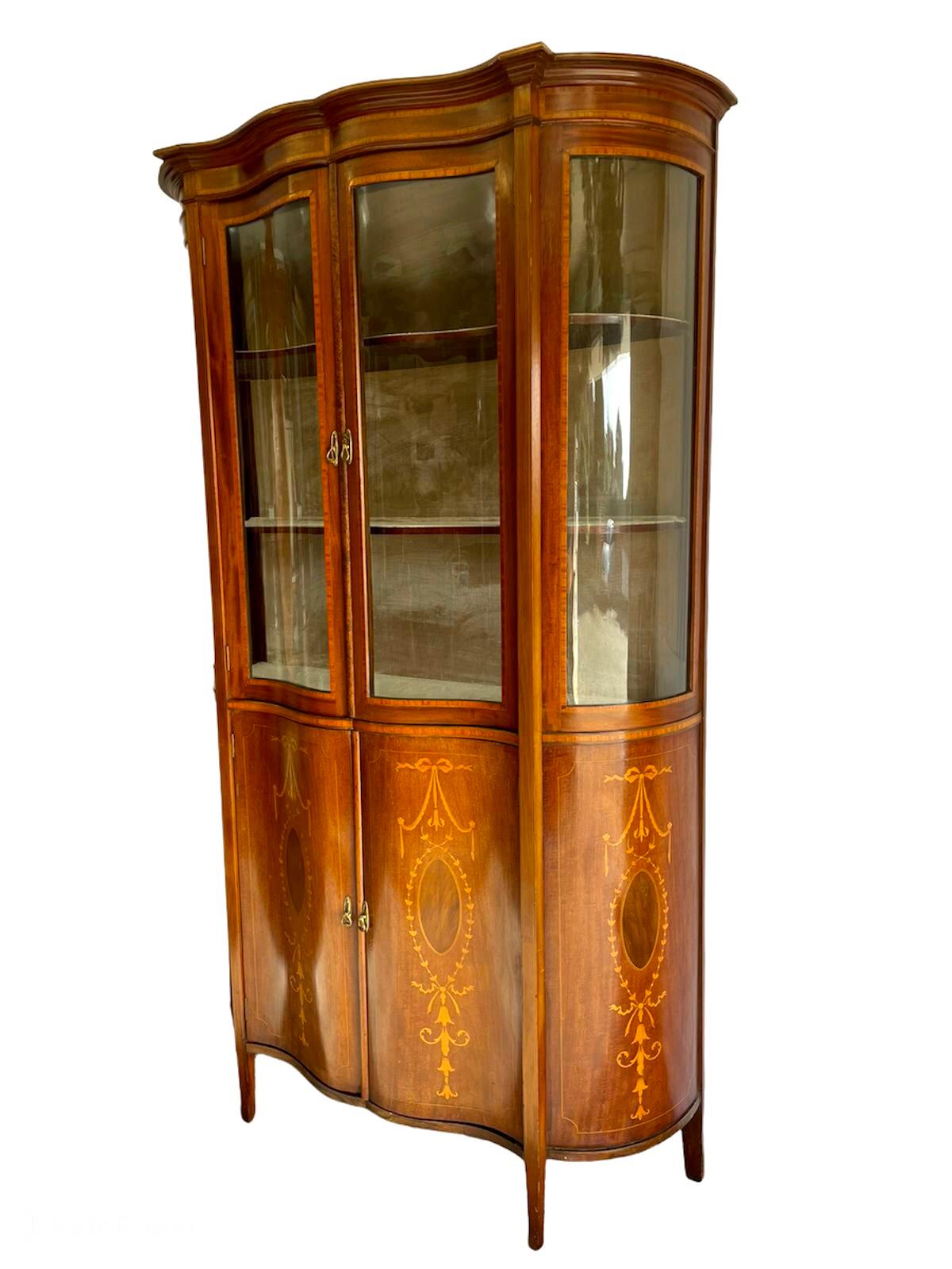 Fine antique 19th century Victorian mahogany inlaid serpentine shaped display cabinet having a very attractive serpentine shaped top section with pretty inlaid cornice, serpentine glazed ends, two inlaid shaped mahogany glazed doors with original
