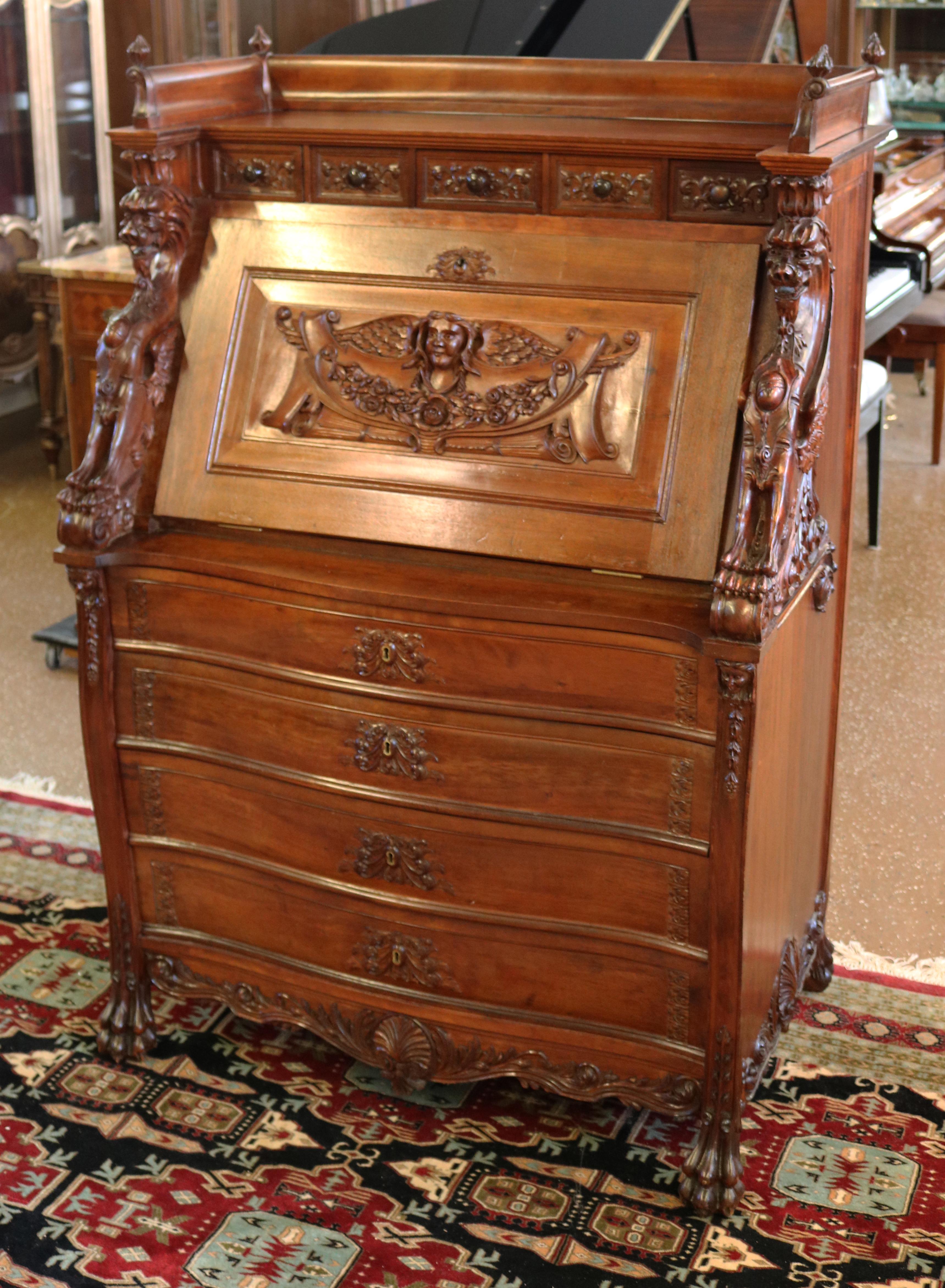 This late 19th century slant front desk was made in the USA most likely by R.J Horner of NYC. The desk is made of a fine mahogany and has two griffins flanking each side of the drop front desk. This piece is stunningly carved and lots of storage and