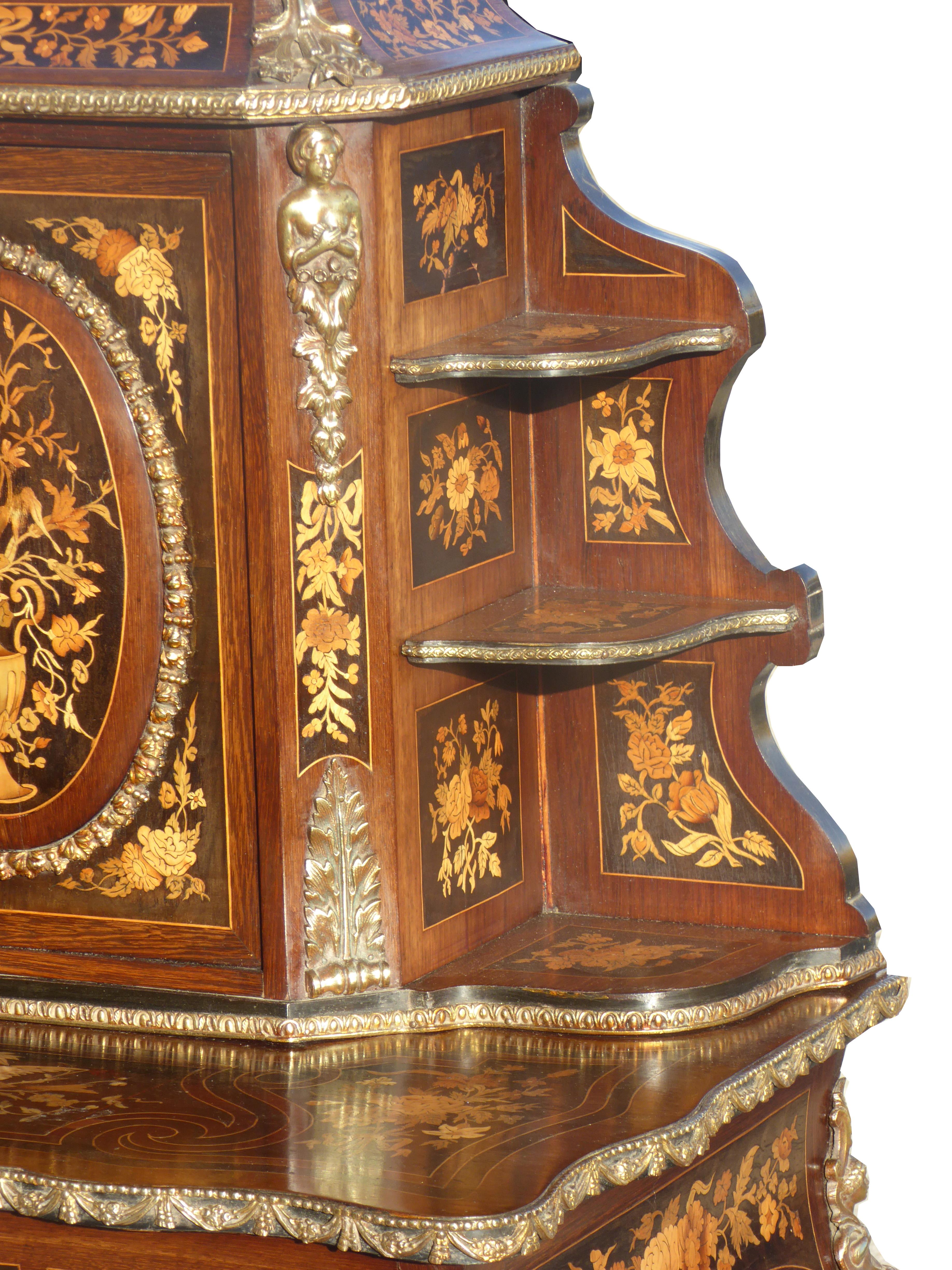 For sale is a very good quality Victorian Marquetry Bon Heur De Jour. The top of the piece is intricately inlaid and has a brass gallery, above a central cupboard, flanked by ormolu mounts opening to reveal an interior fitted with several drawers