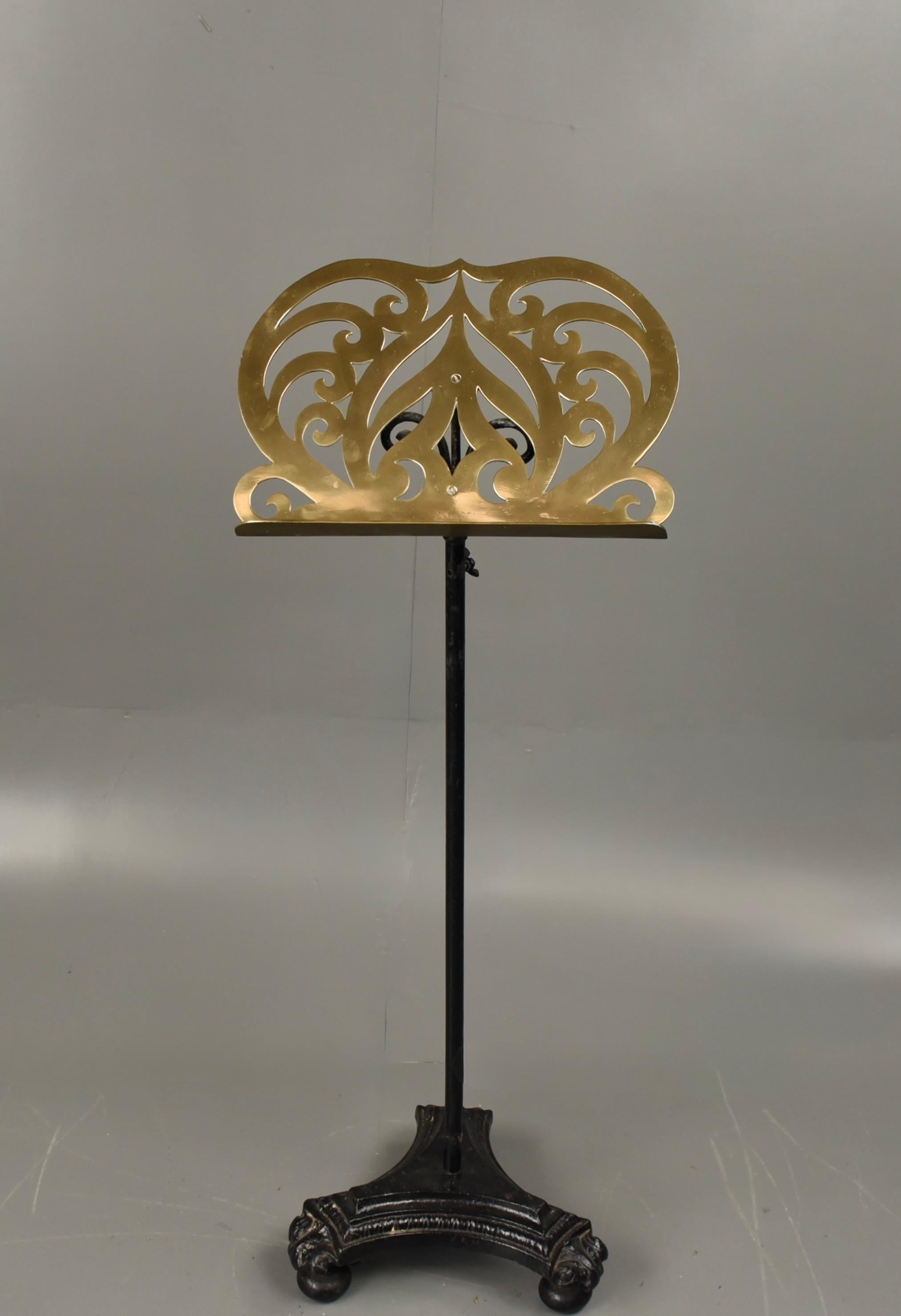 Antique mid Victorian brass and cast iron music stand .
Wonderful decorative solid brass and heavy cast iron music stand , fully height adjustable lowest 121 cm /tallest 158 cm dimensions to top of stand . 
Ornate heavy cast iron base ,it stands