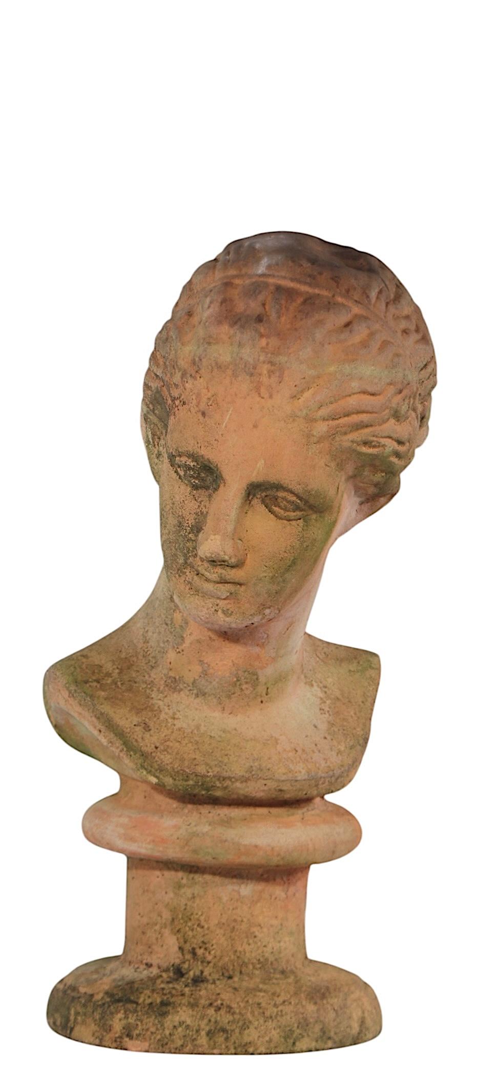 Classical terracotta bust in very good original condition showing only light cosmetic wear normal and consistent with age.
 The bust depicts a woman’s head, her hair is tied back in a bun, a' la classical  Greek or Roman statuary . This example is