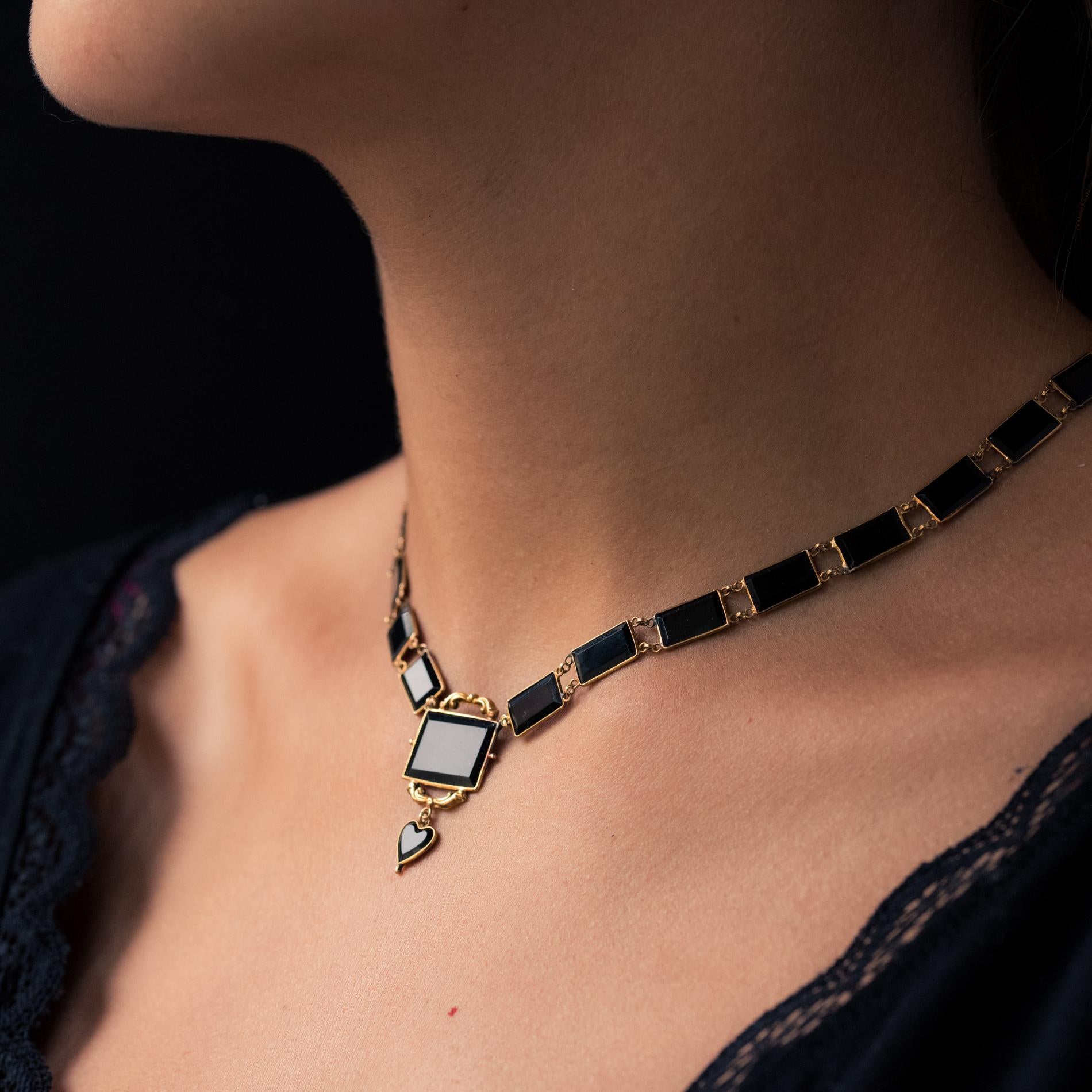 Necklace in 14 karat yellow gold necklace, shell hallmark.
Lovely antique choker necklace, it is made up of thin closed set onyx plates linked together with gold rings. On the front, a larger onyx is bordered with scroll patterns and supports in a