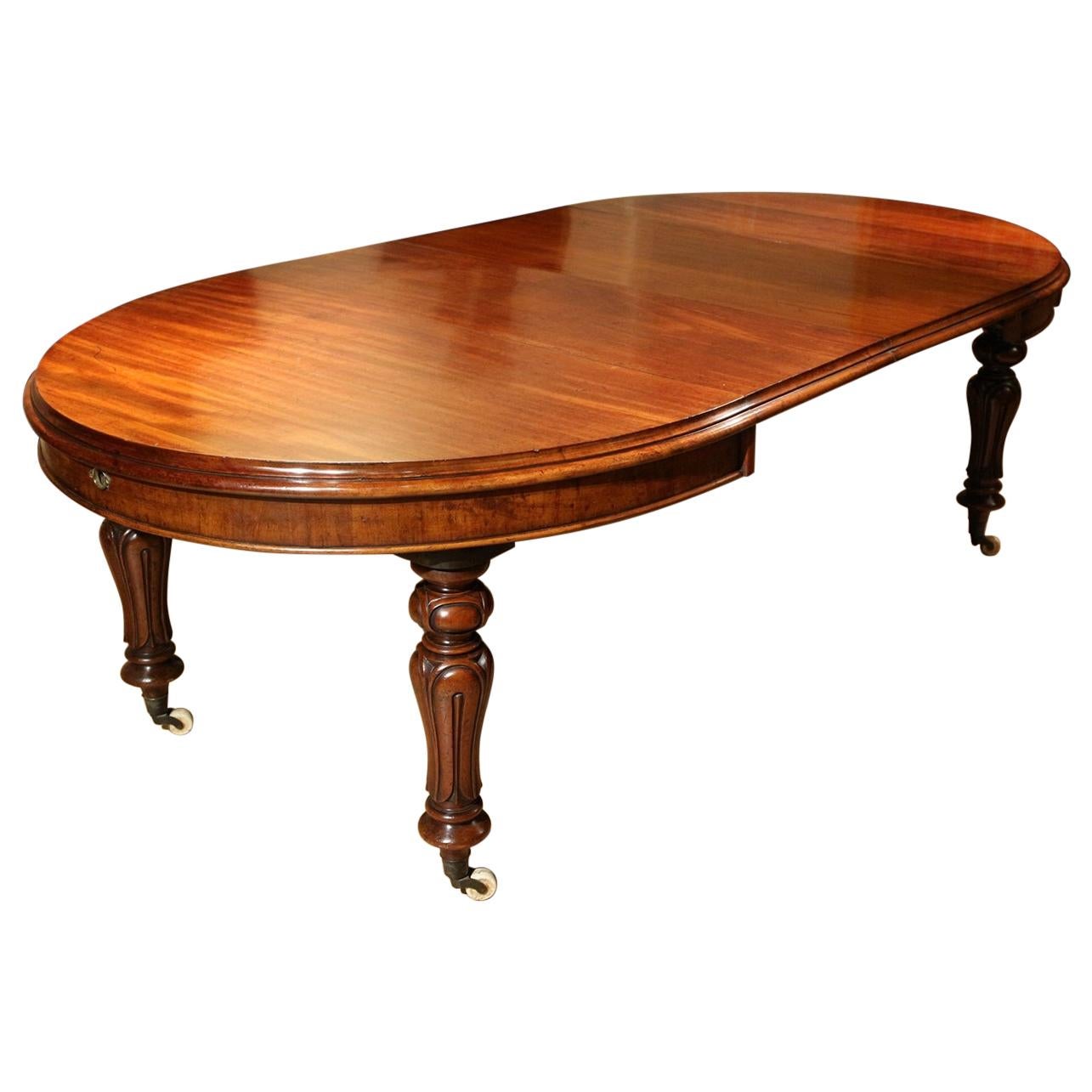 Beautiful antique mahogany oval dining room table with 2 extra leaves. The table is from the Victorian era circa 1840 and is entirely of solid mahogany. The table is on porcelain wheels. Table is in perfect and completely original condition.